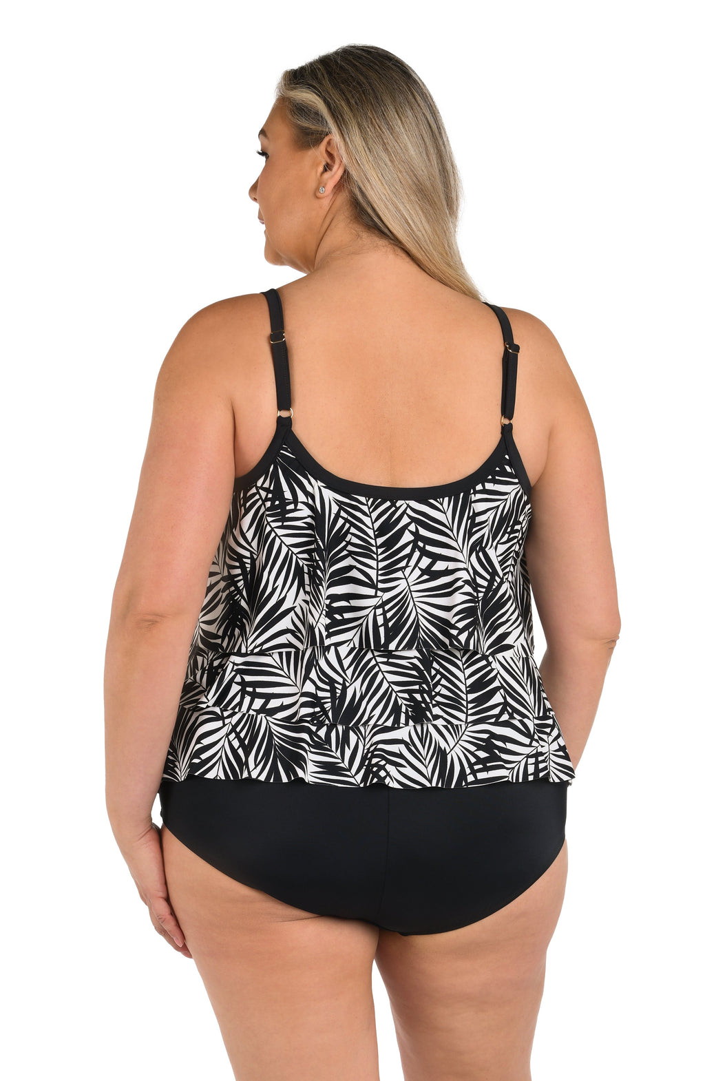 Person wearing a black and white patterned tankini top on a white background