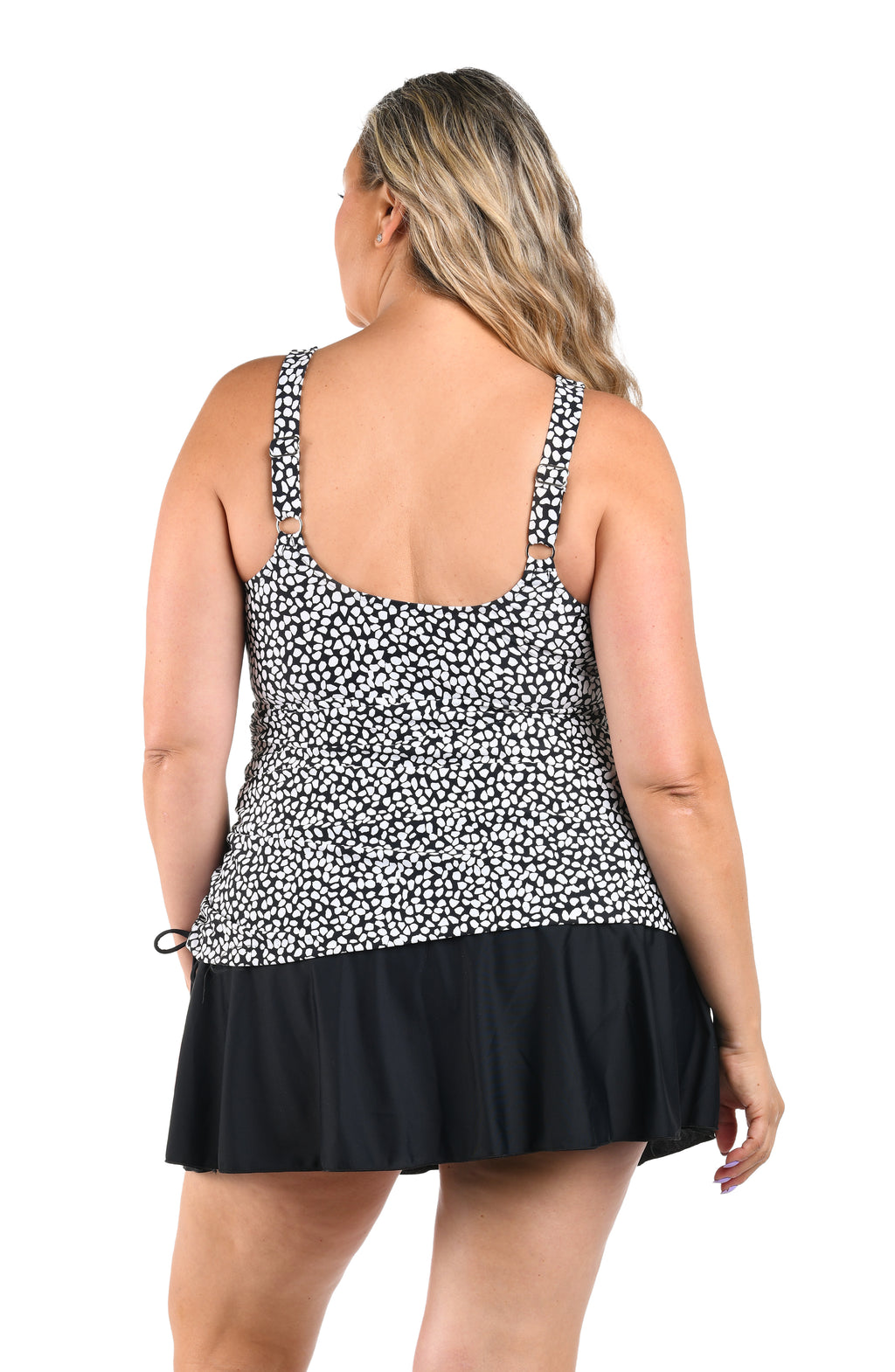 Woman wearing a black and white patterned dress with a plain background