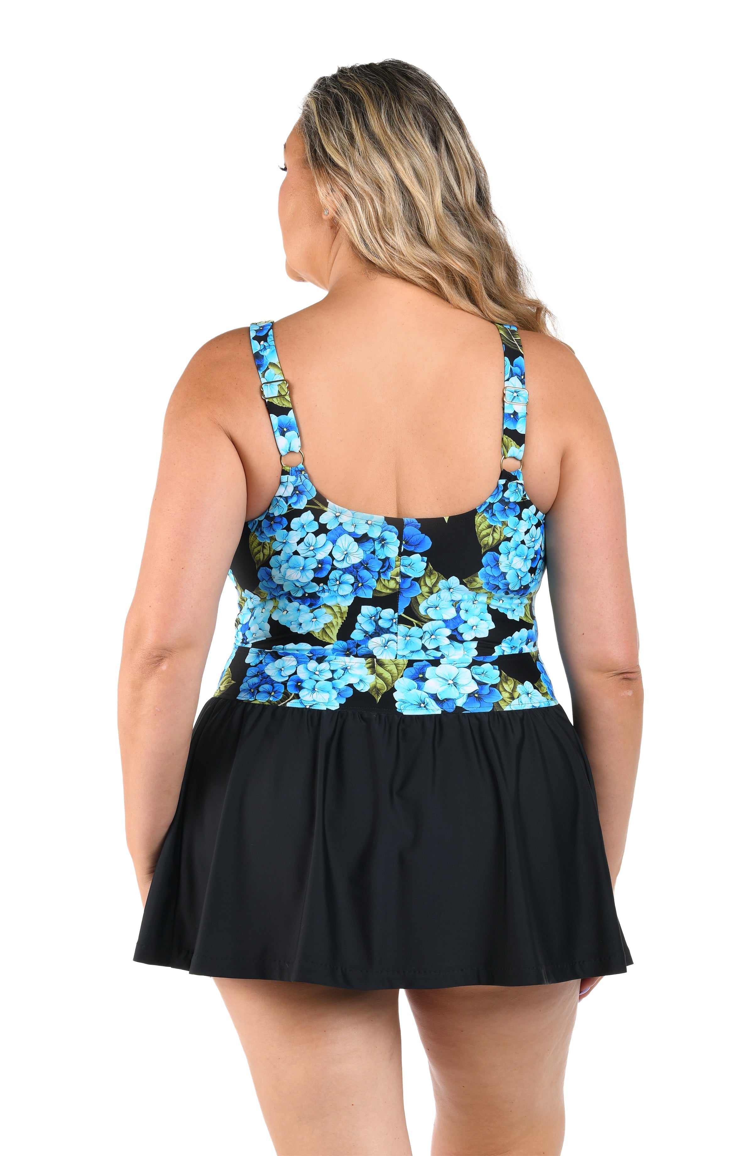 Woman wearing a black dress with blue floral patterns on a white background