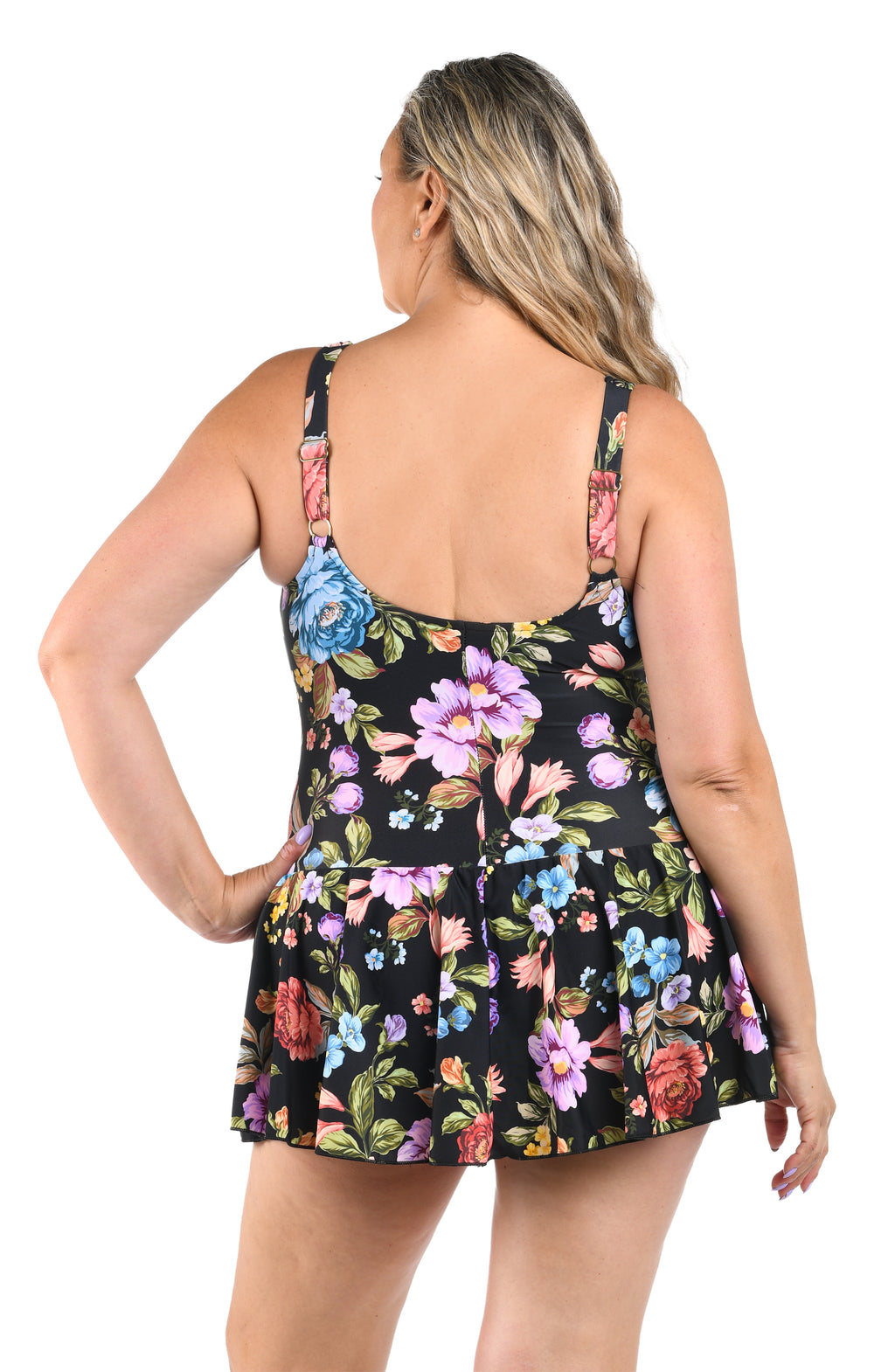 Woman wearing a black floral dress with colorful flowers on a white background