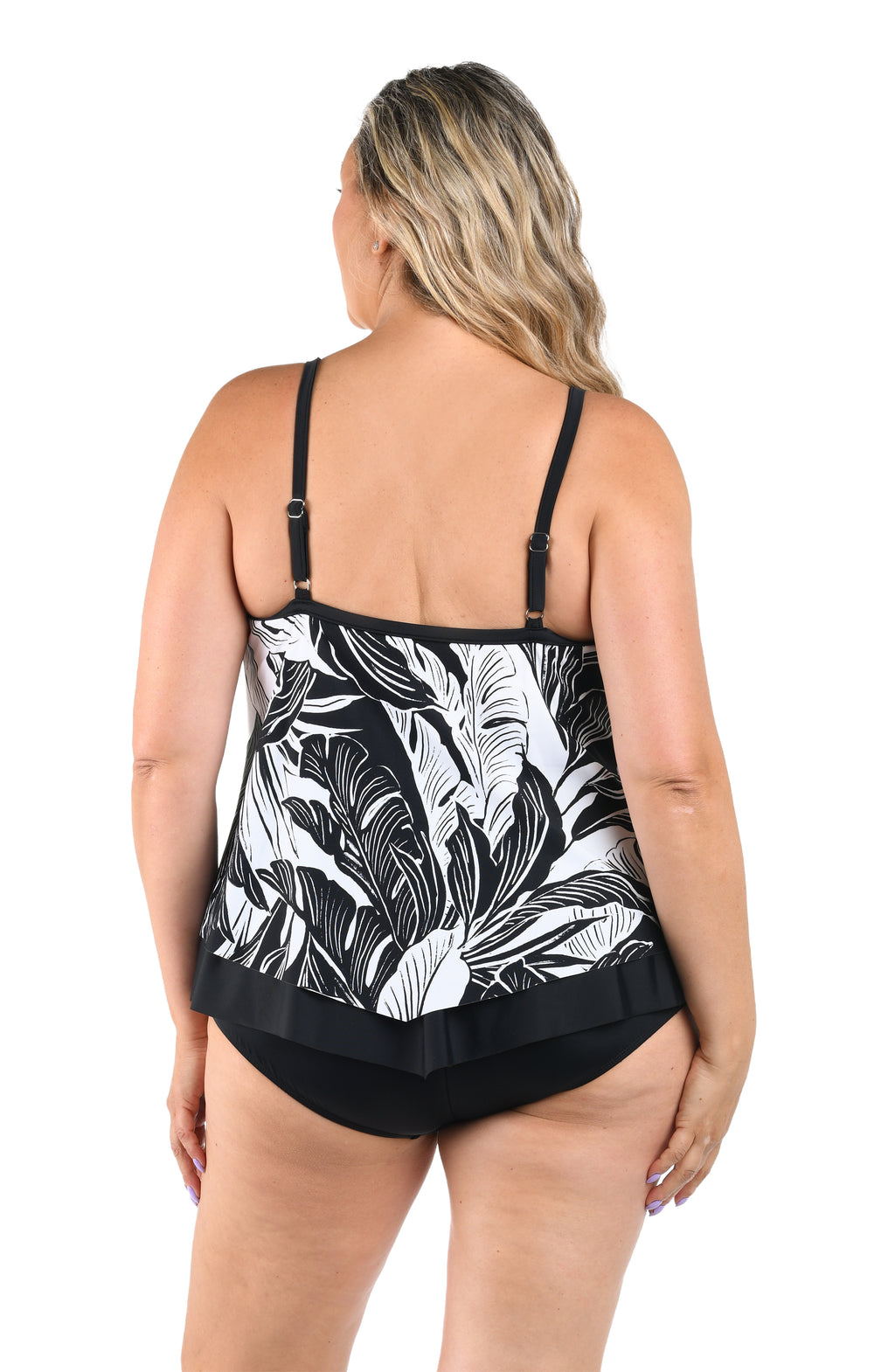Woman wearing a black and white leaf-patterned swimsuit on a white background