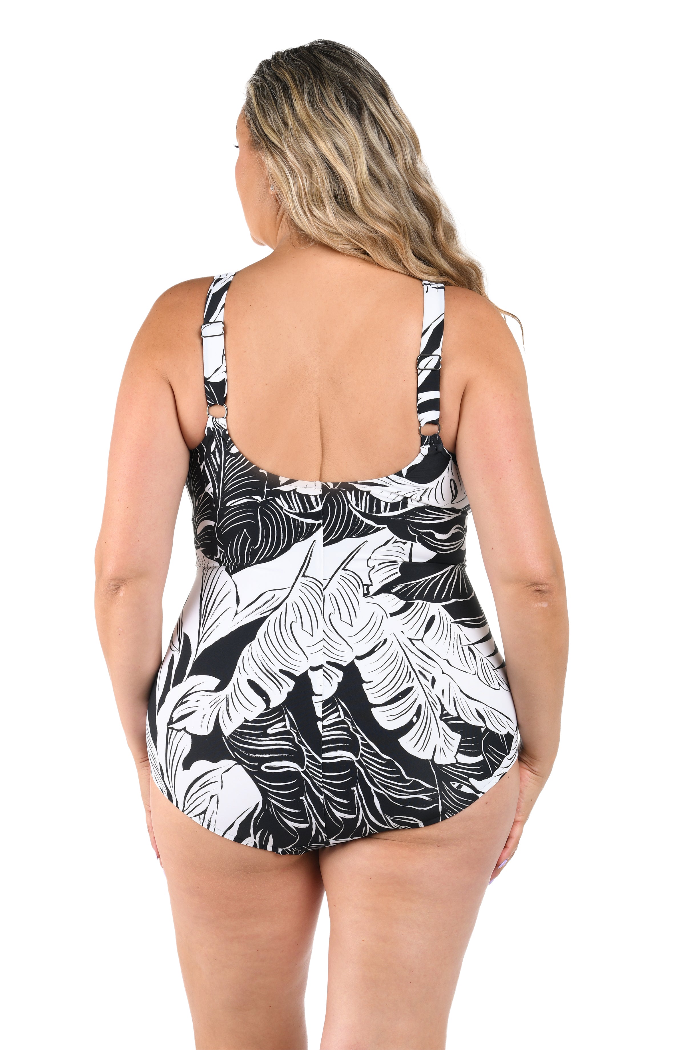 Woman wearing a black and white leaf-patterned swimsuit on a white background