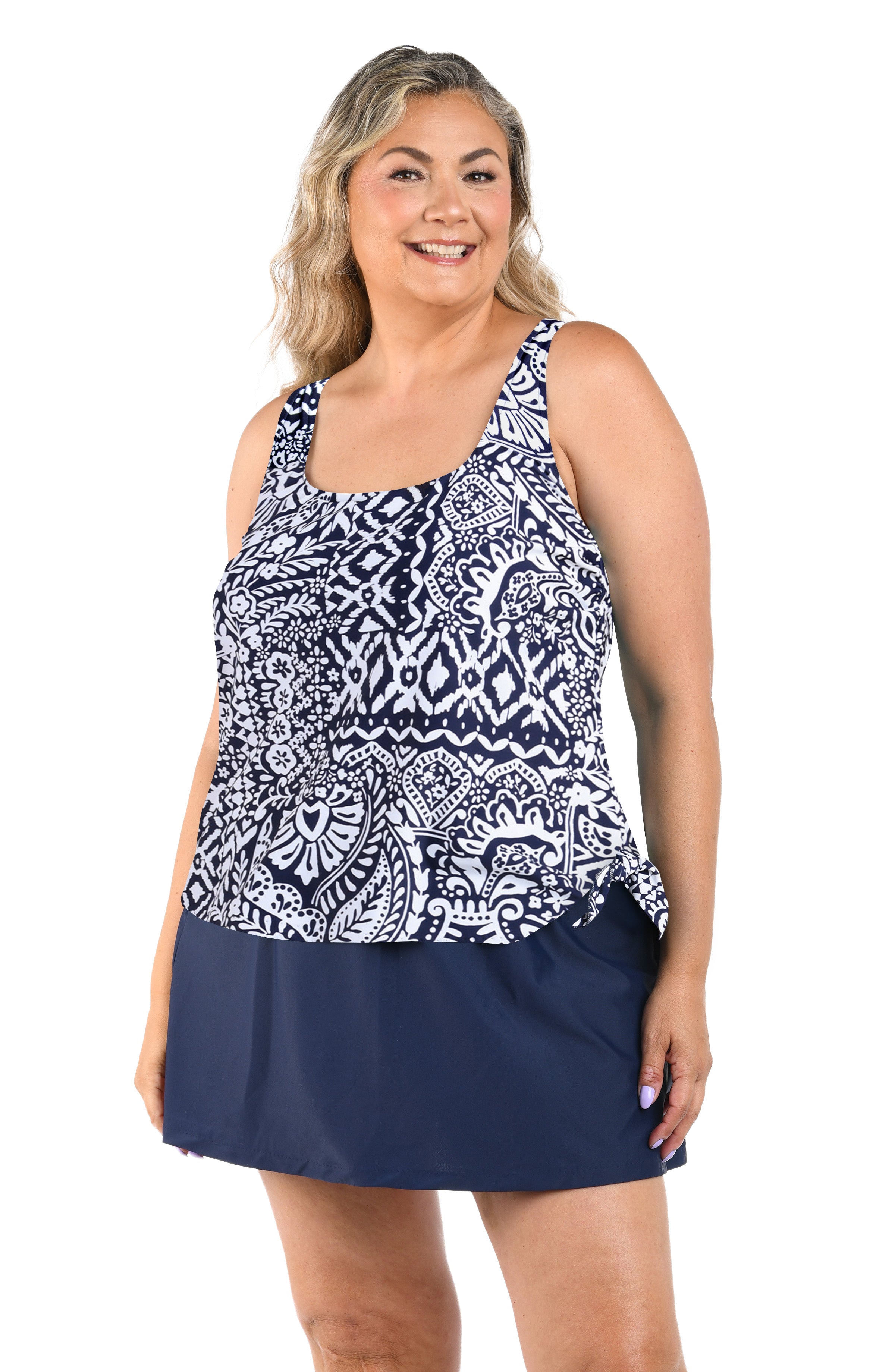 Woman wearing a tankini top with a pattern and navy skirt on a white background