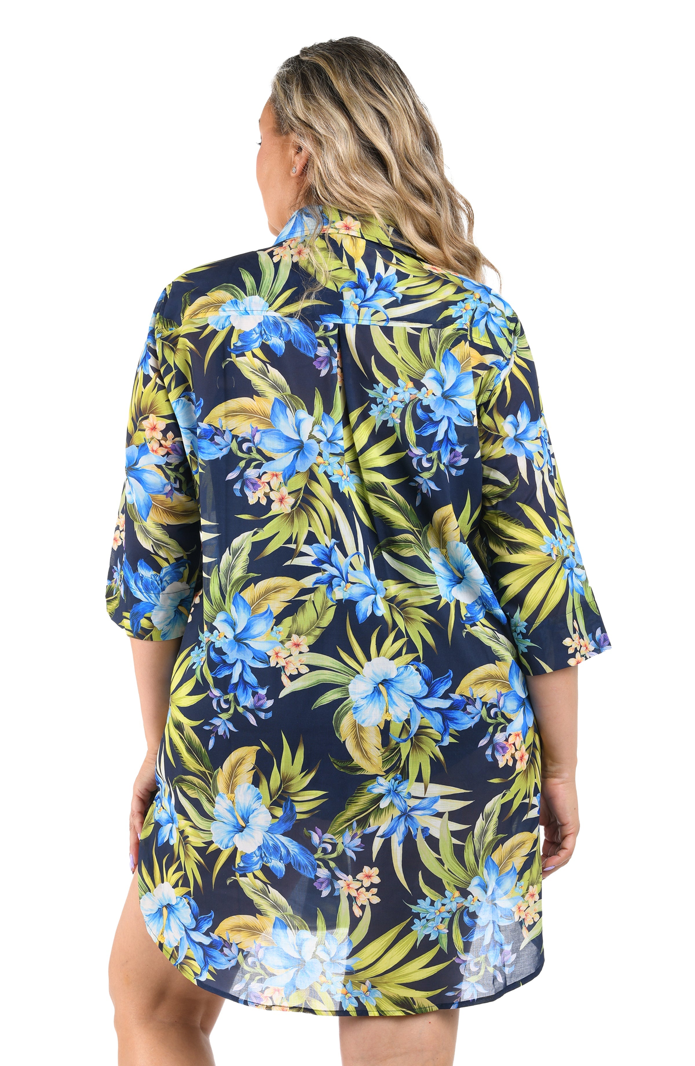 Woman wearing a navy floral dress with blue and green flowers on a white background