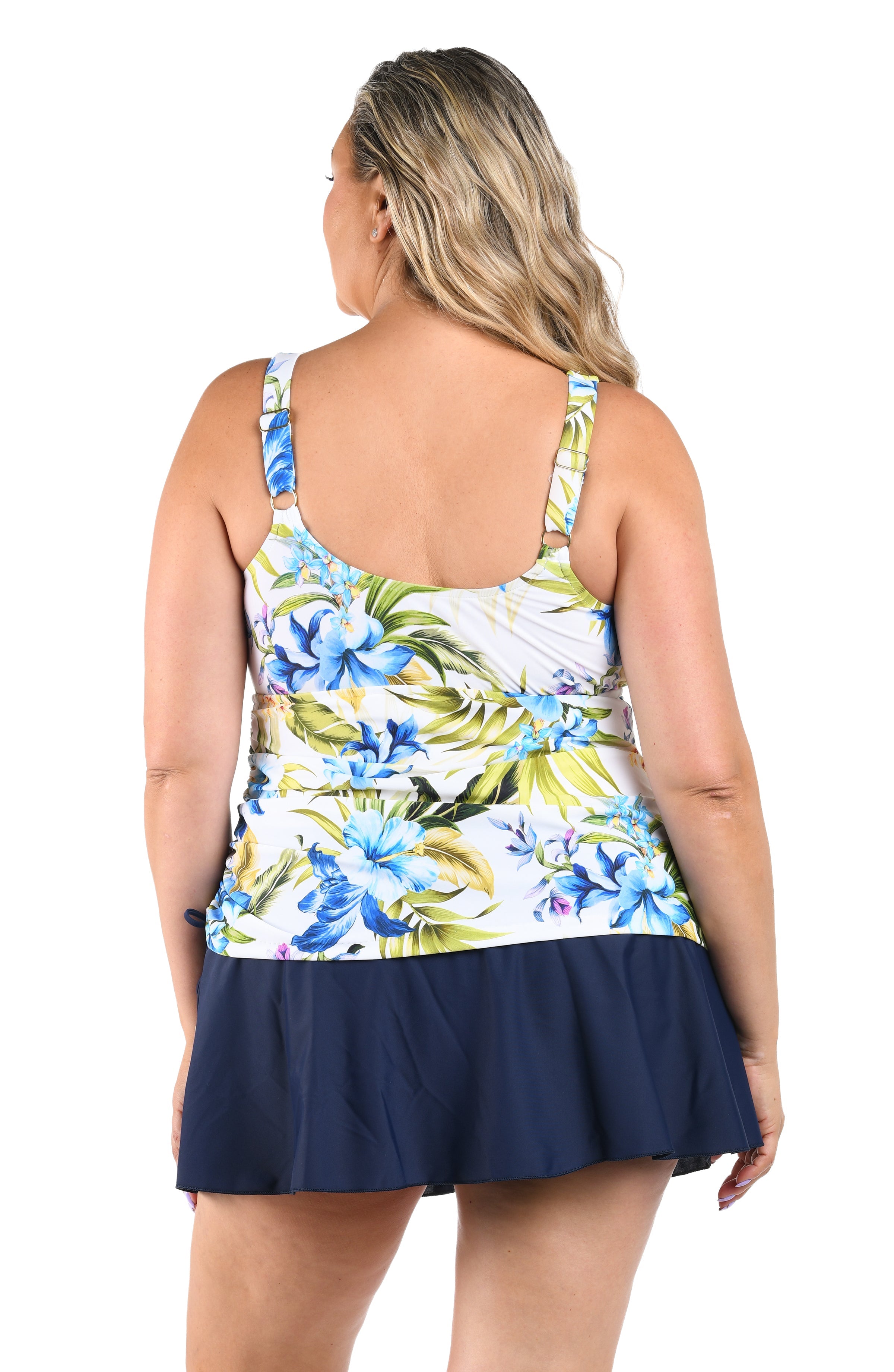 Woman wearing a floral tank top with a navy skirt on a white background