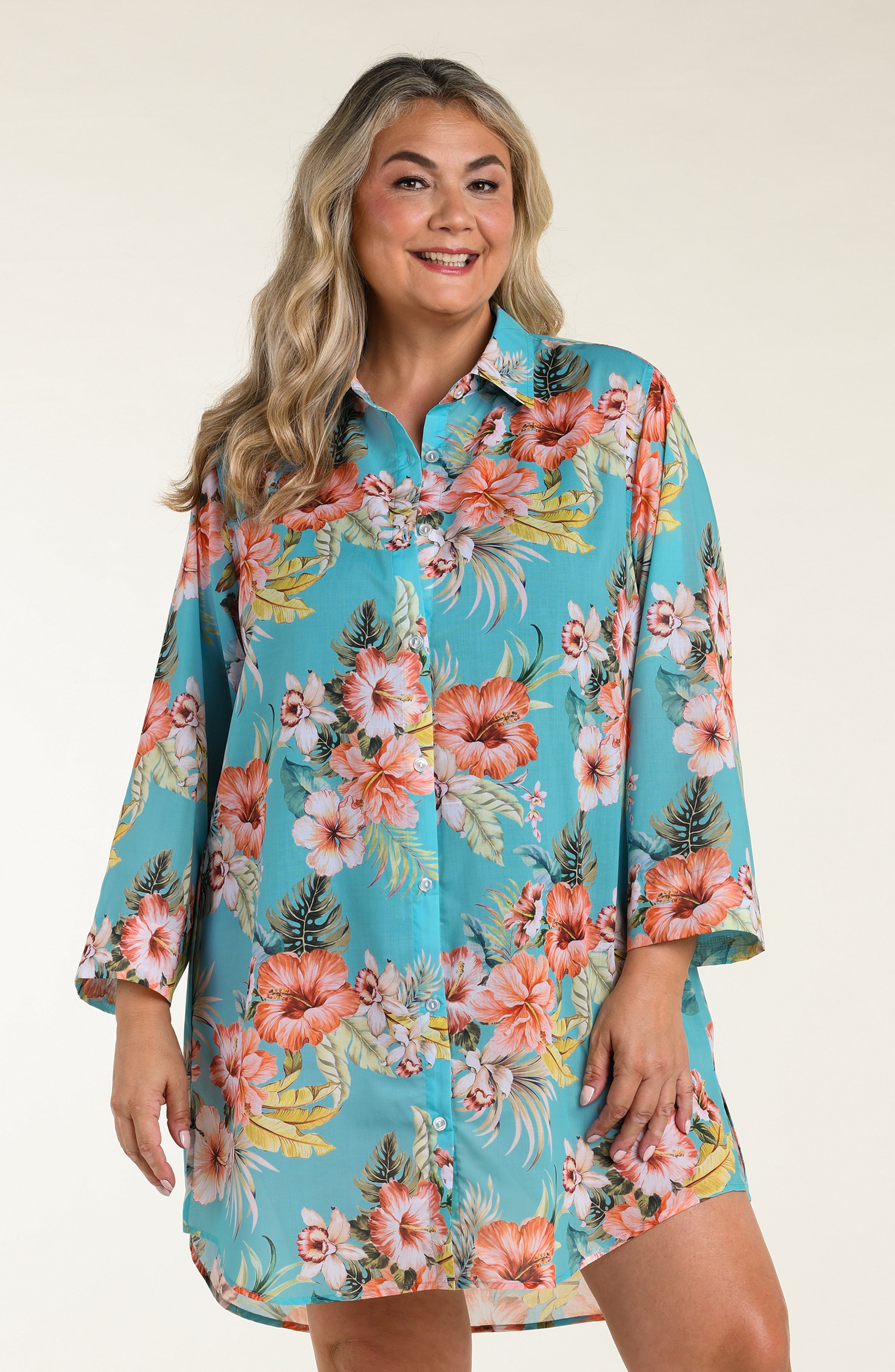 Woman wearing a floral cover up tunic with a white background