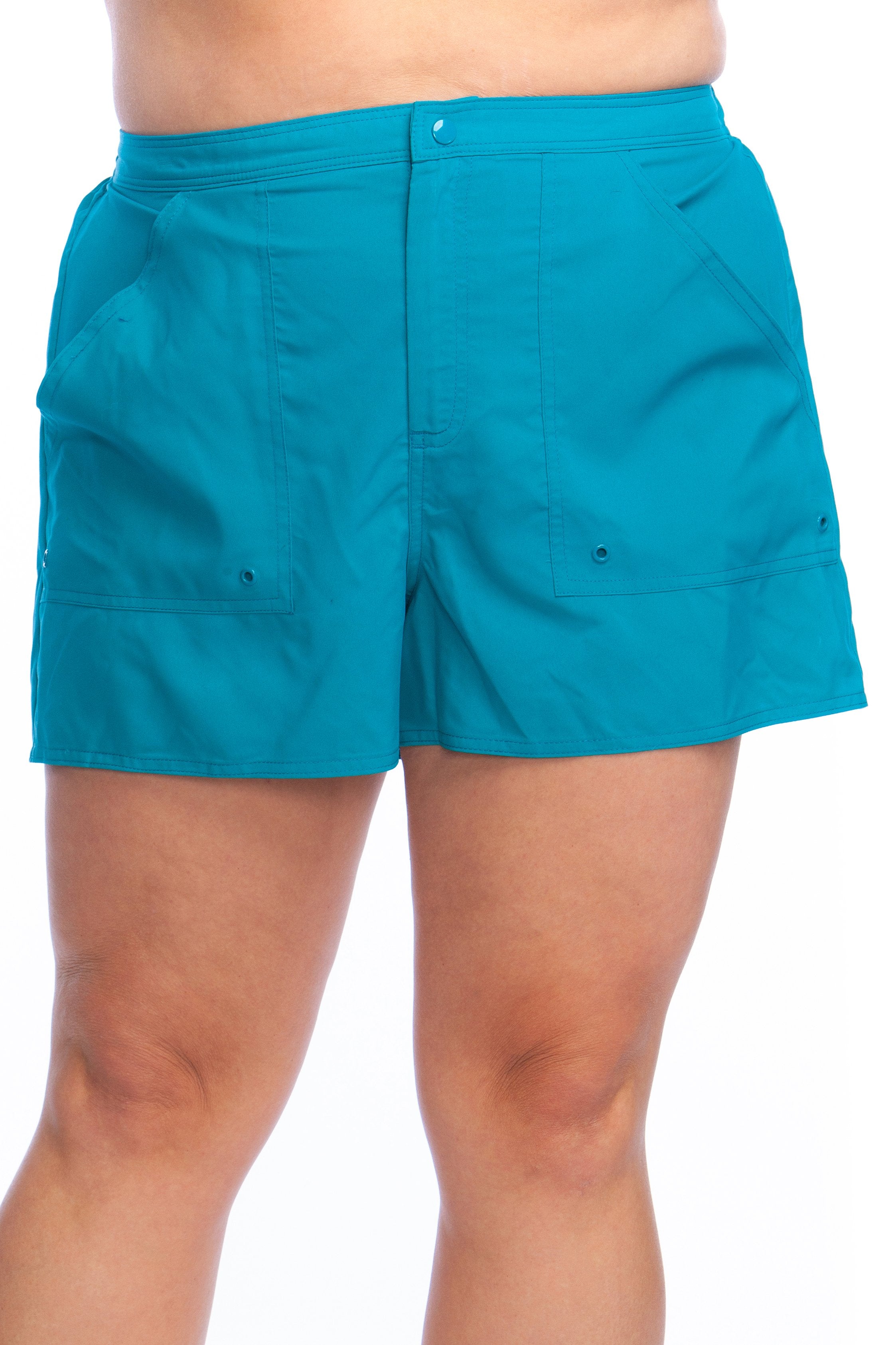 Emerald colored board shorts against a white background.