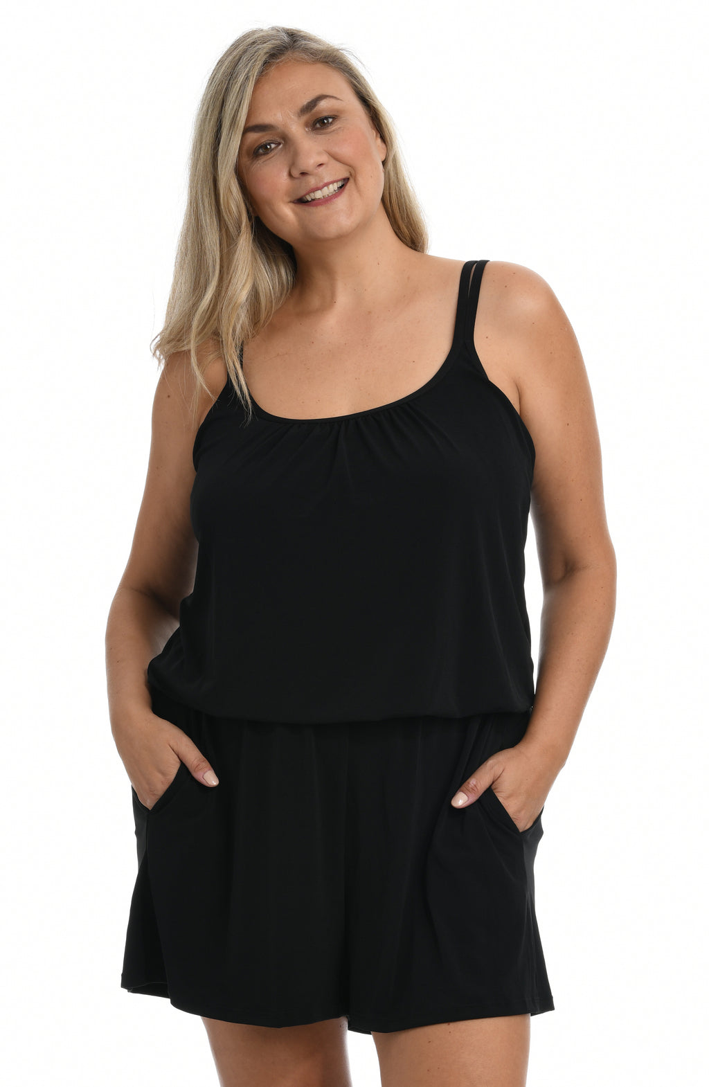 Woman wearing a black swim romper one piece against a white background