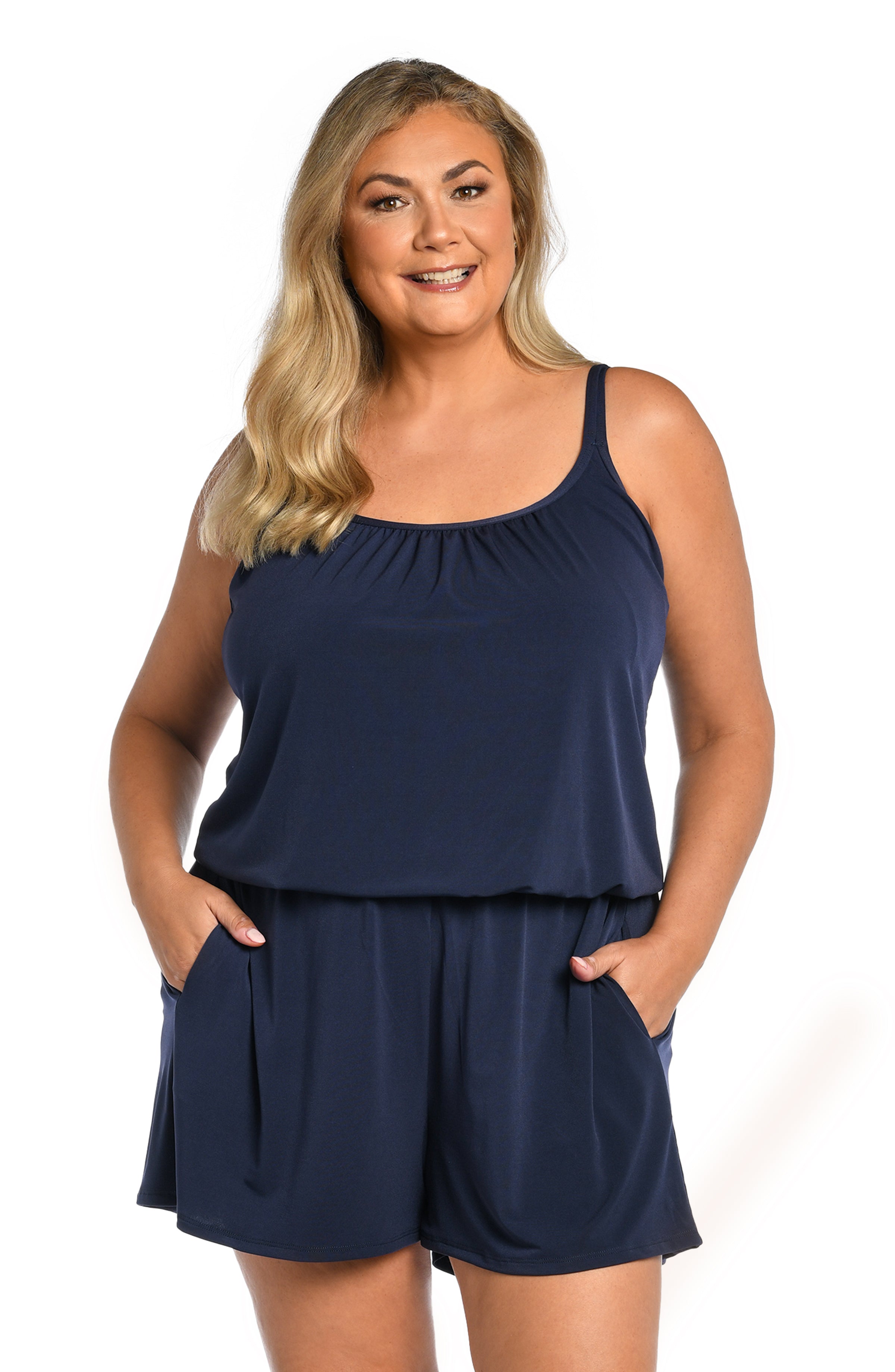 Woman wearing a navy blue swim romper one piece set on a white background
