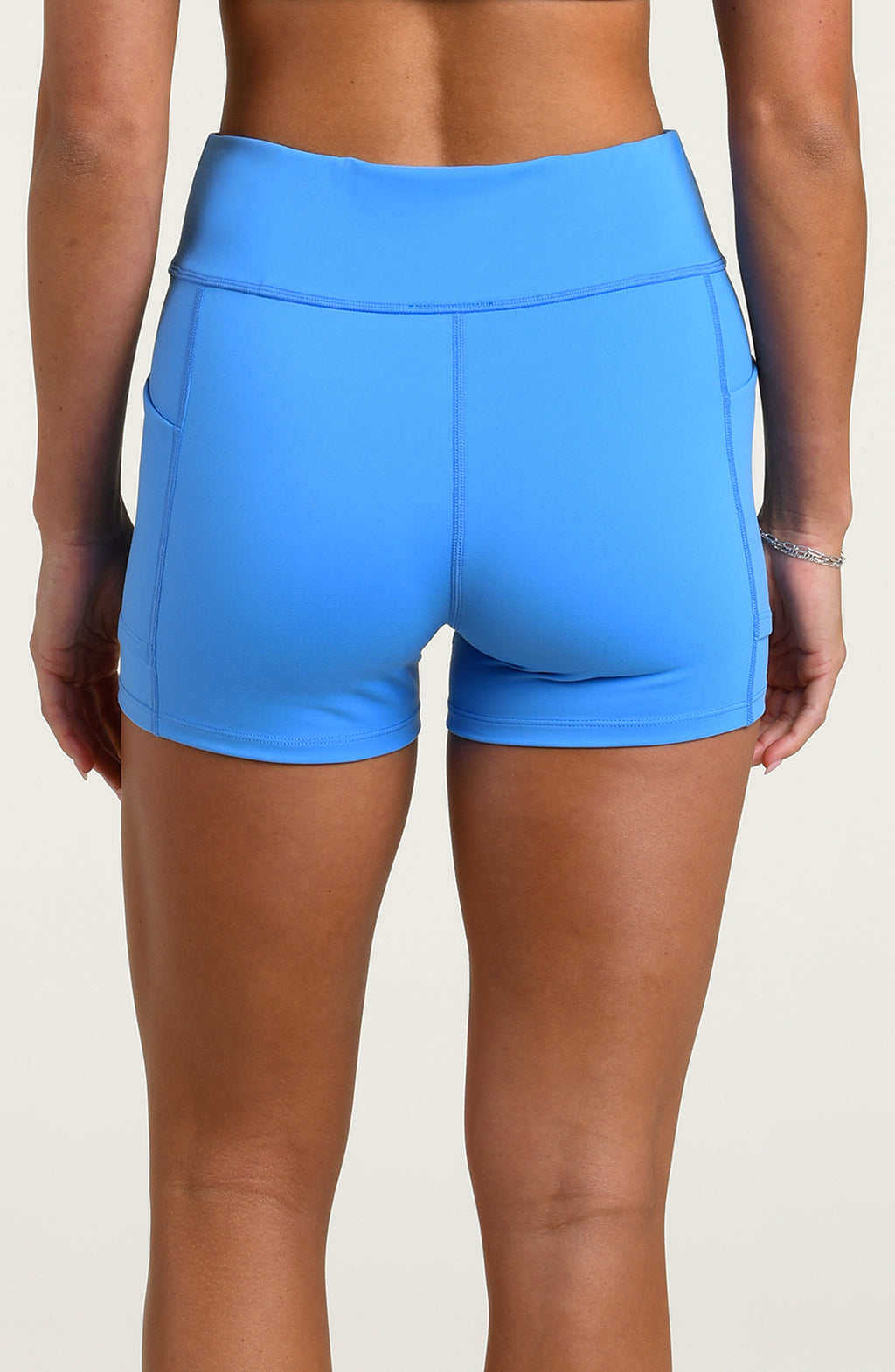 Woman wearing blue biker shorts against a white background.