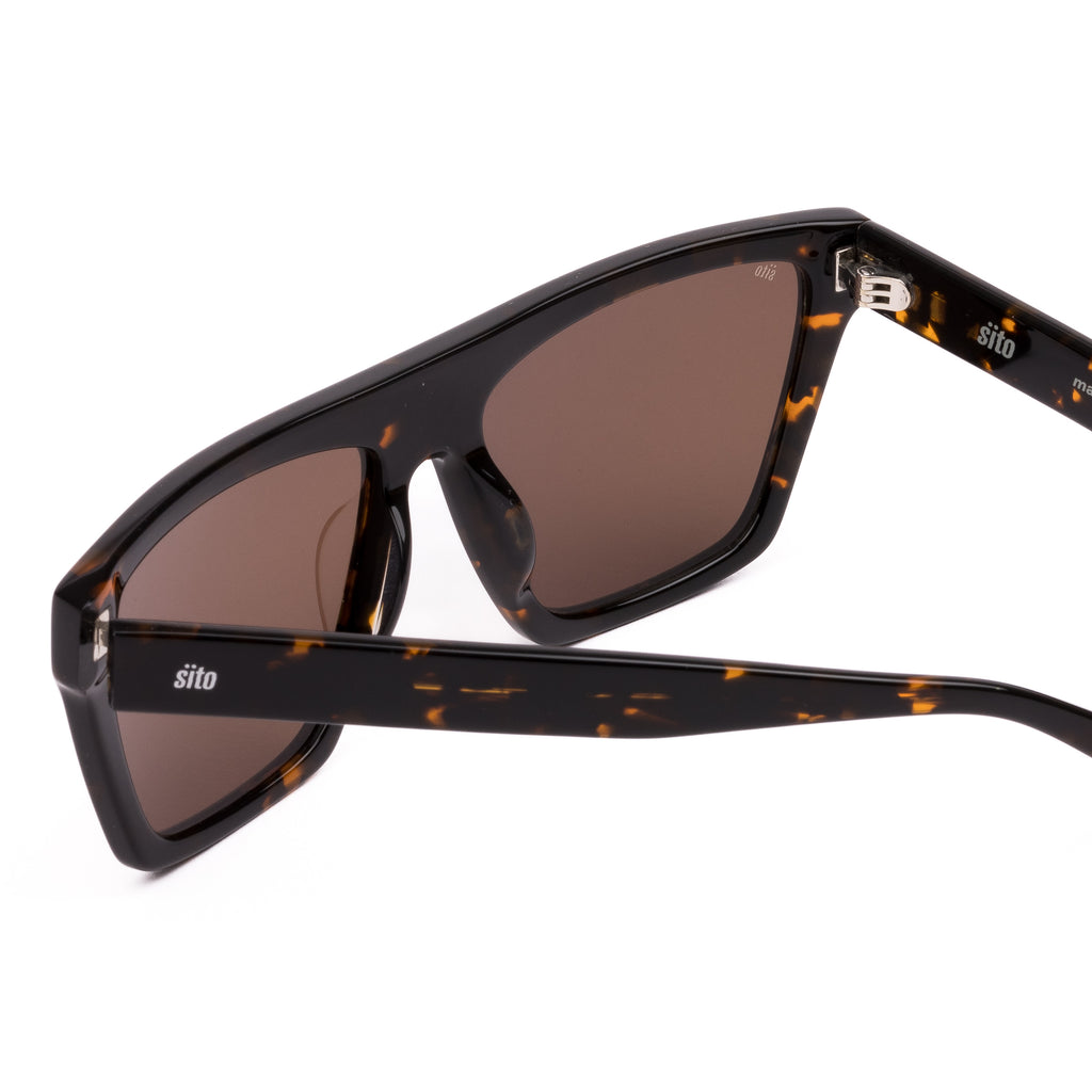 Sunglasses with tortoiseshell frame and brown lenses on a white background