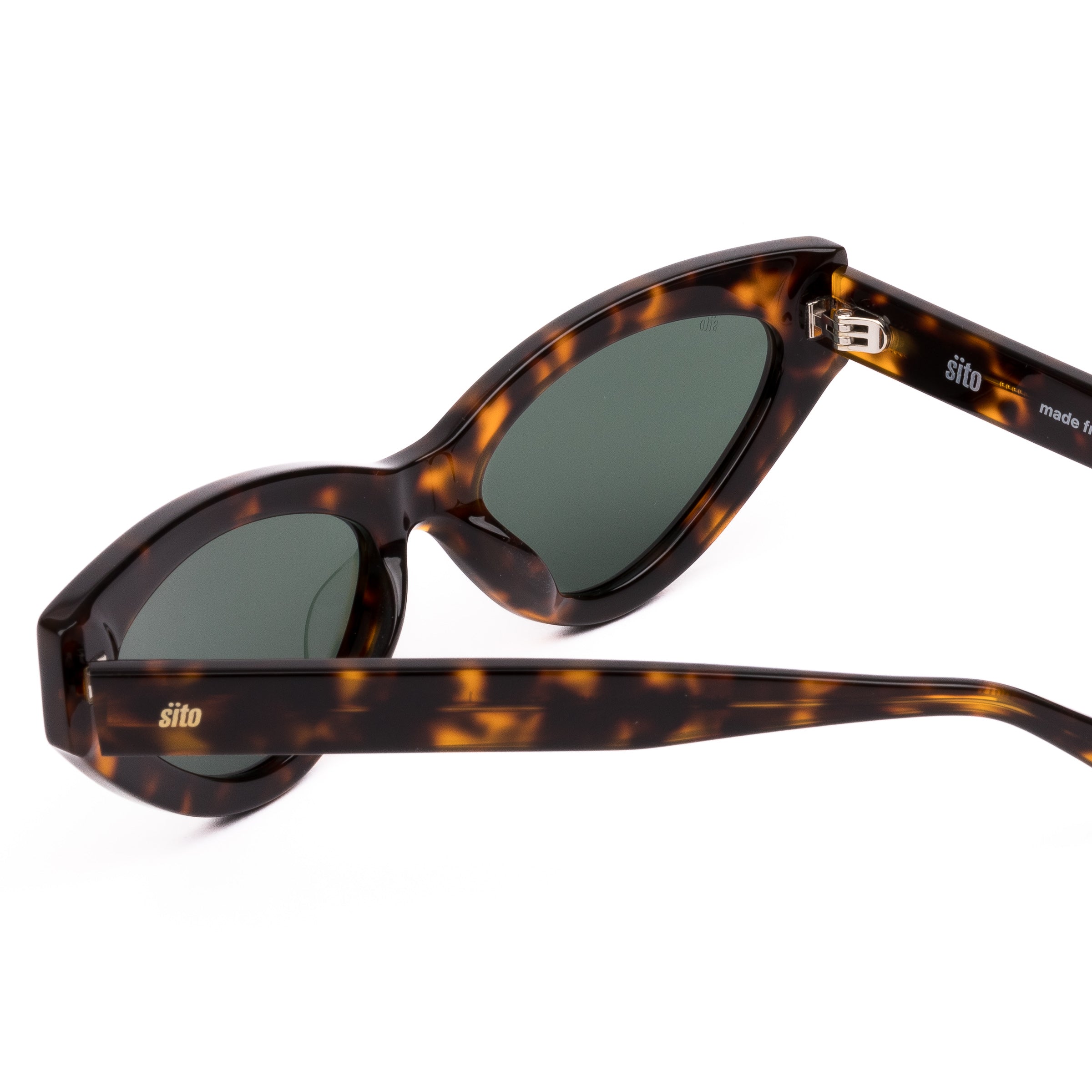 Cat-eye sunglasses with tortoiseshell frame and dark lenses on a white background
