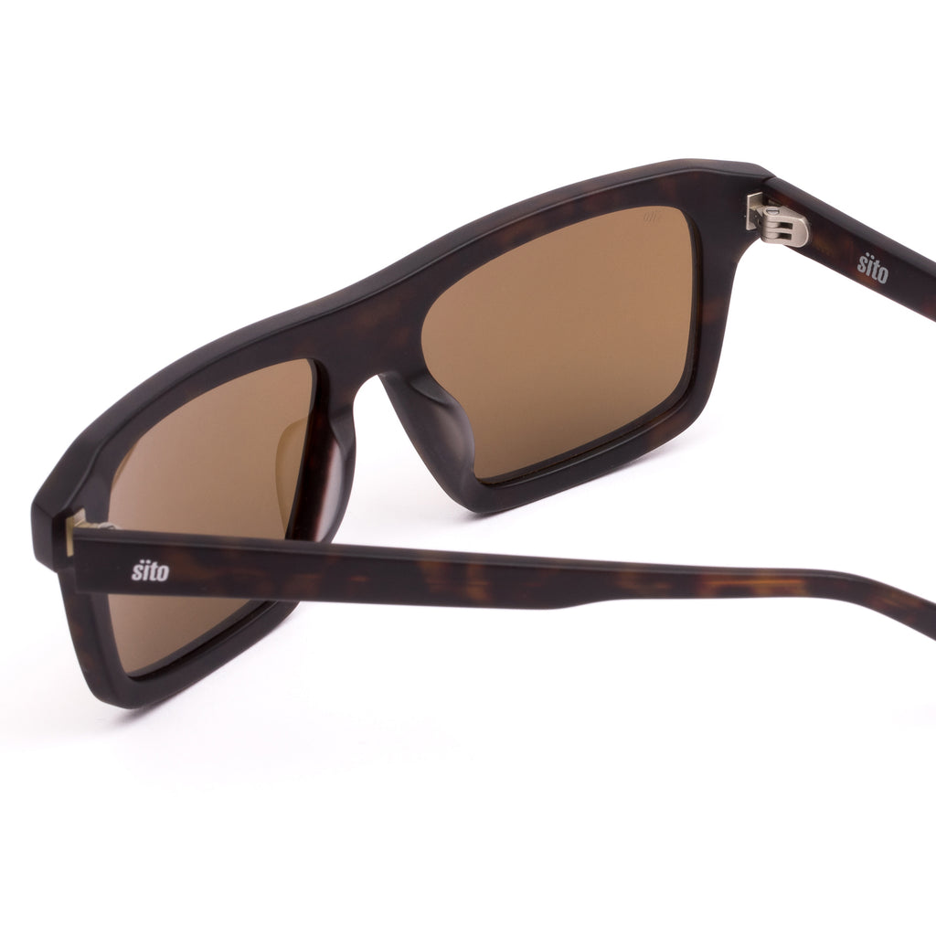 Sunglasses with tortoiseshell frame and brown lenses on a white background