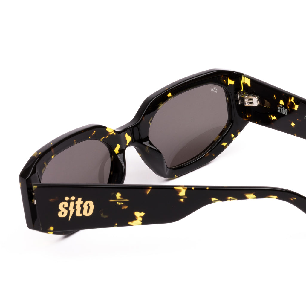 Sunglasses with black and gold tortoiseshell frame on a white background