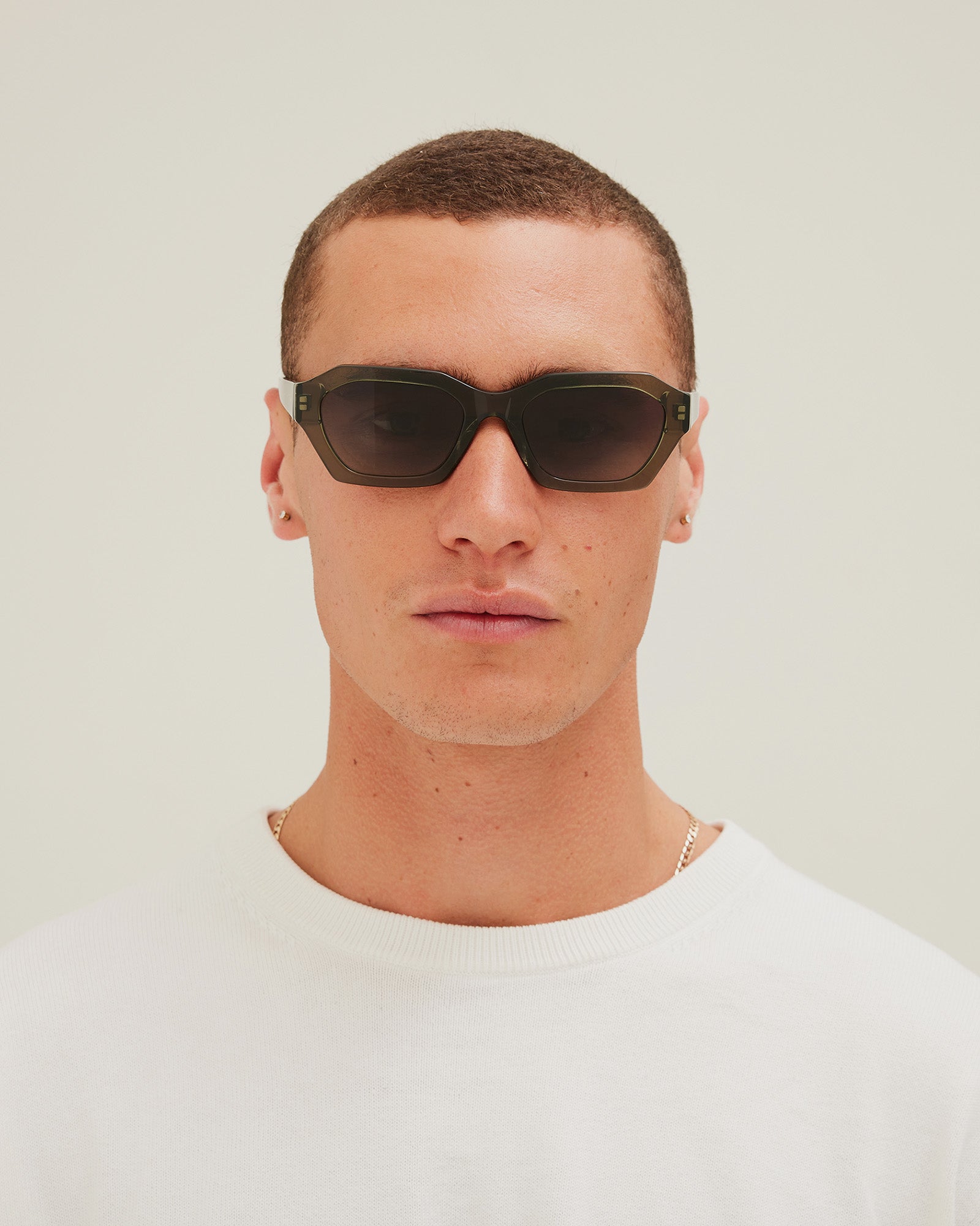 Man wearing green sunglasses with a gradient lens on a white background