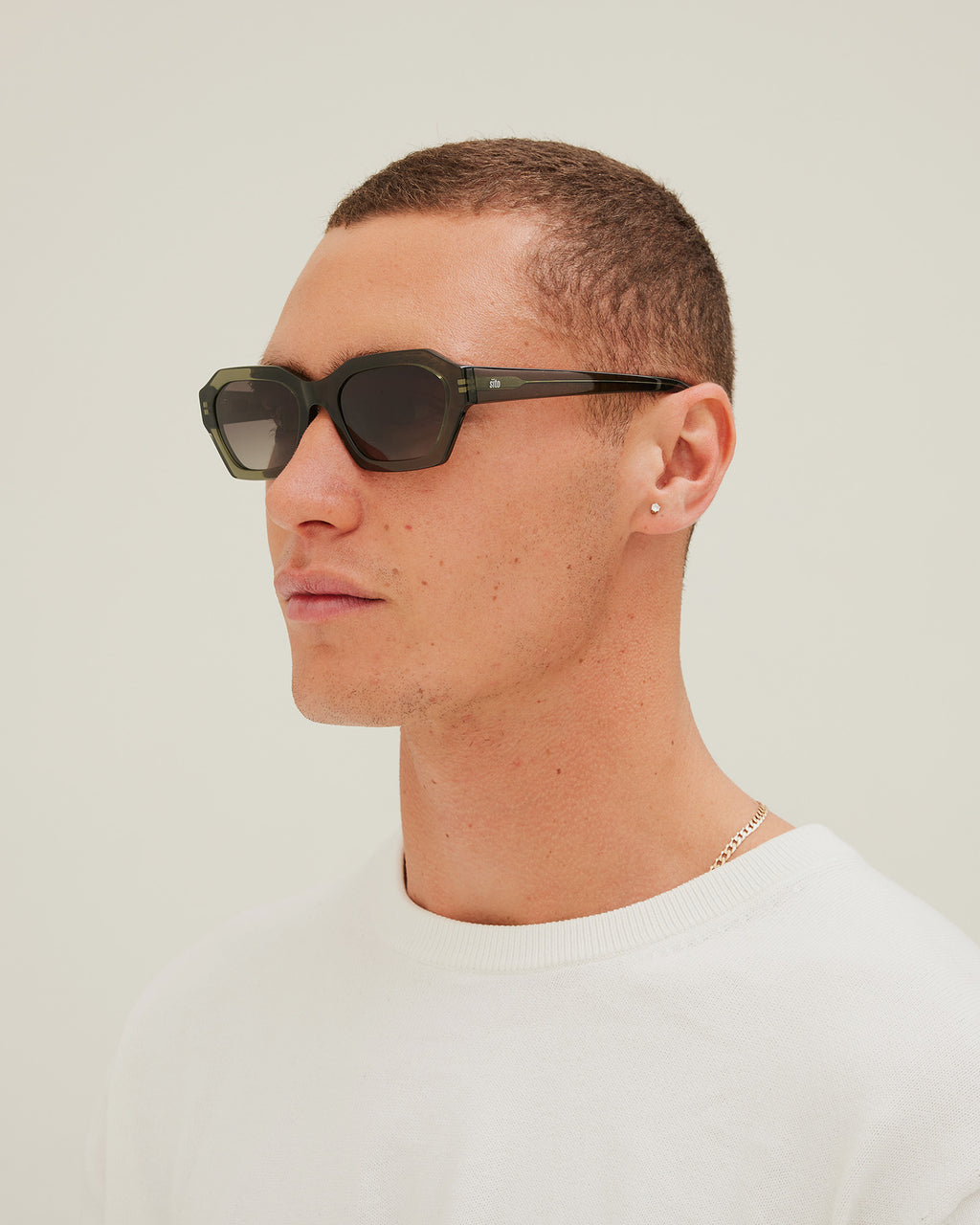 Man wearing green sunglasses with a gradient lens on a white background