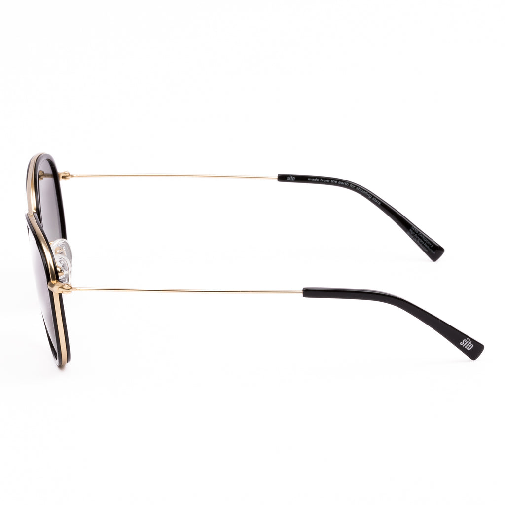 Sunglasses with gold frame and dark lenses on a white background