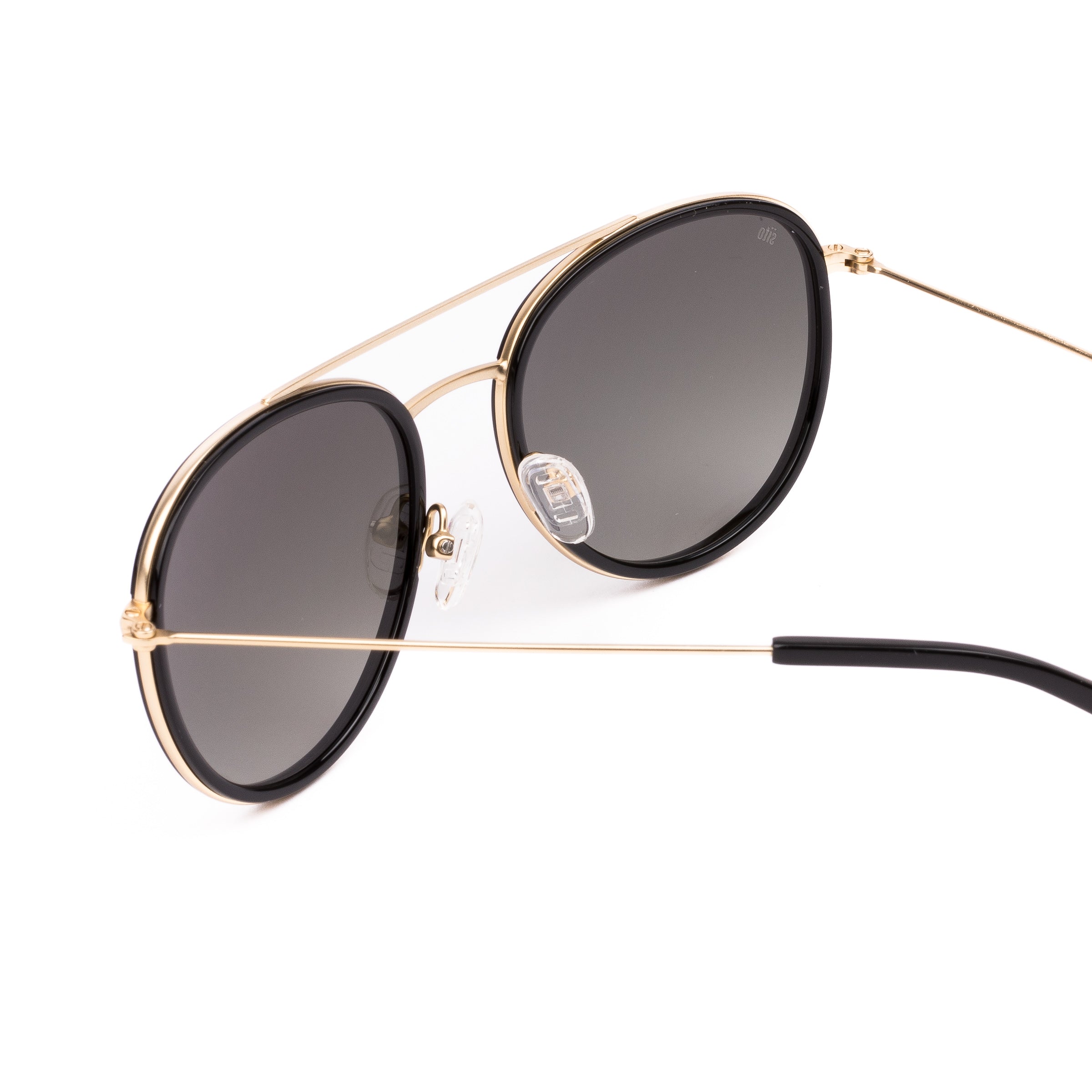 Sunglasses with gold frame and dark lenses on a white background