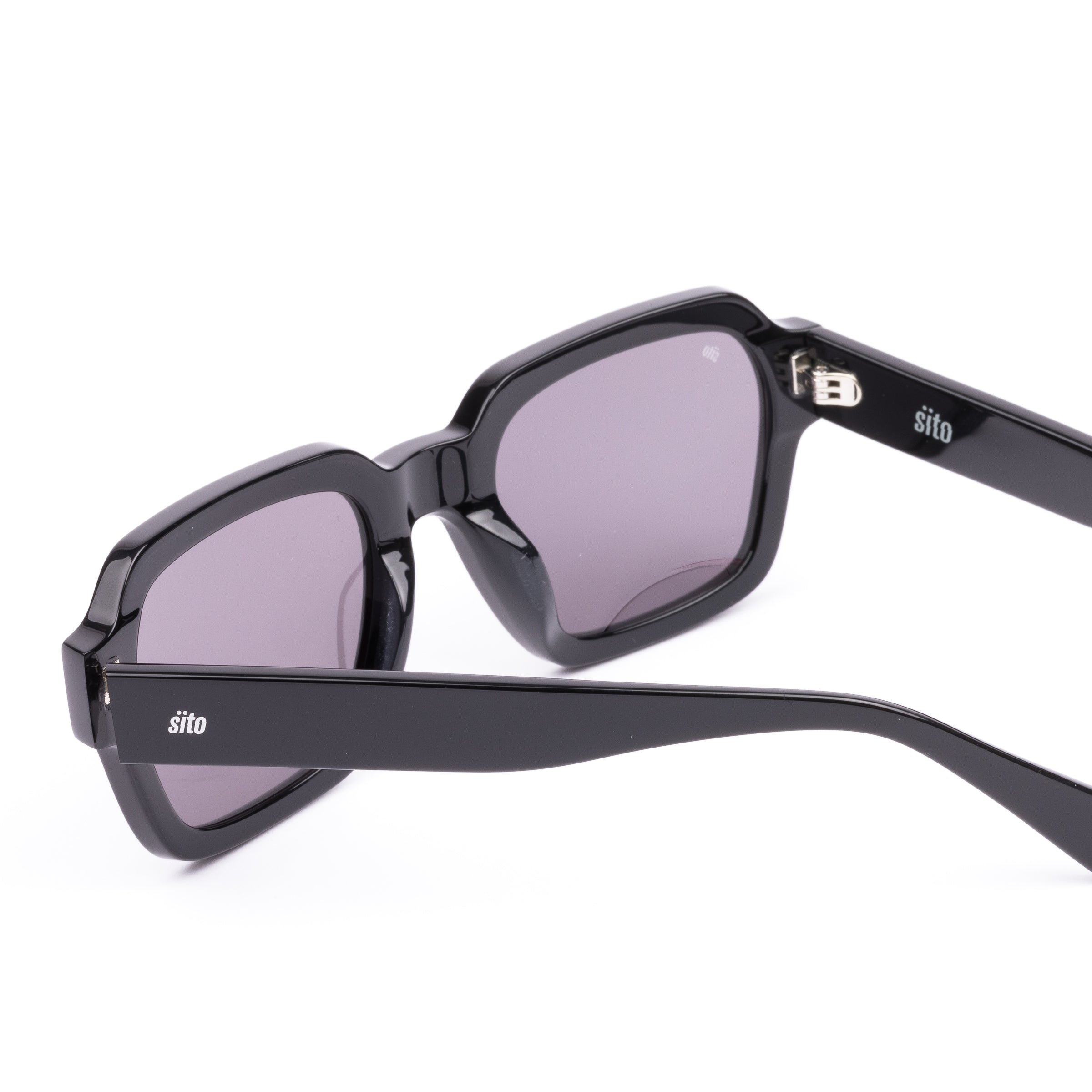 Black sunglasses with a glossy black finish and softly tinted lenses.