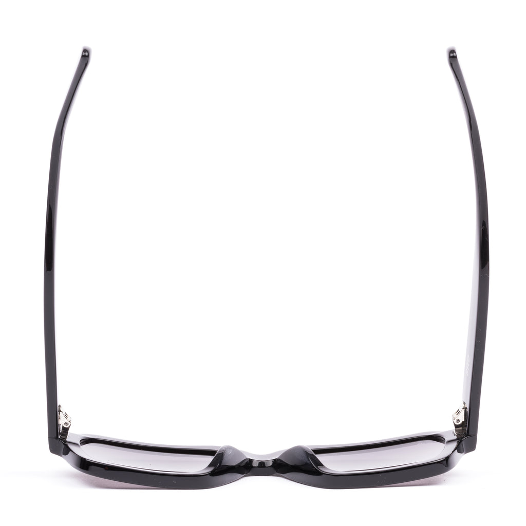 Black sunglasses with a glossy black finish and softly tinted lenses.