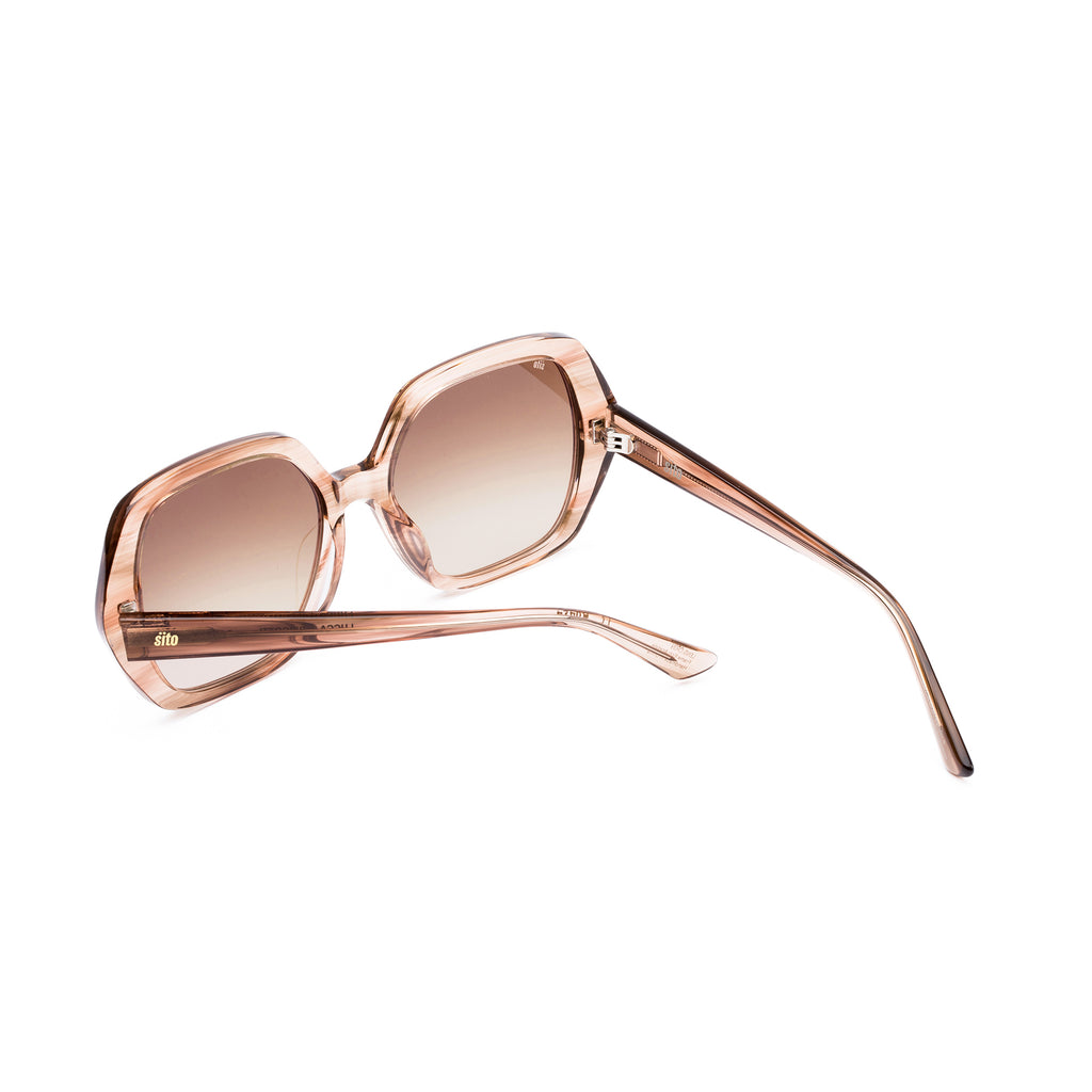 Sunglasses with rose gold frame and gradient lenses on a white background