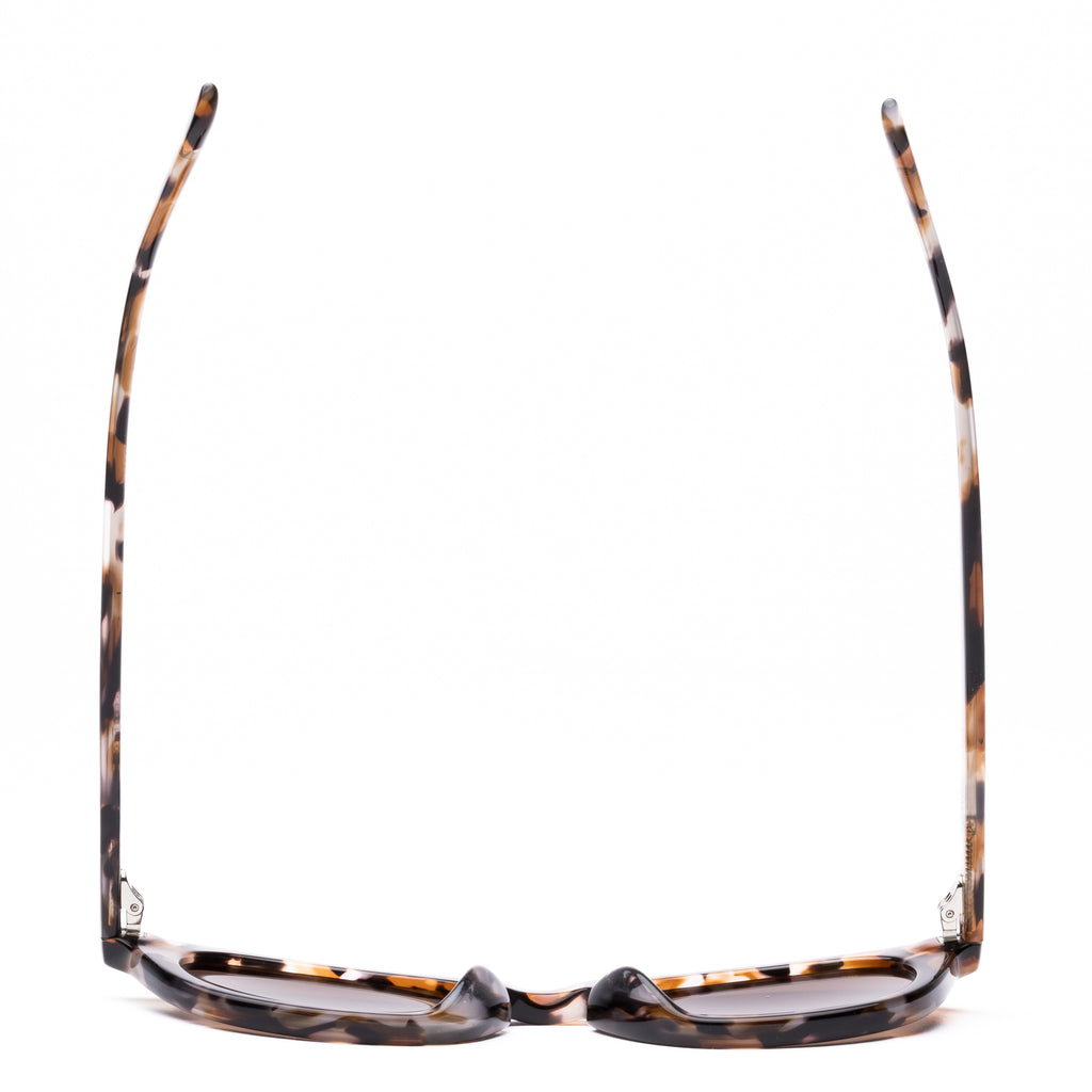 Sunglasses with tortoiseshell frame and brown lenses on a white background