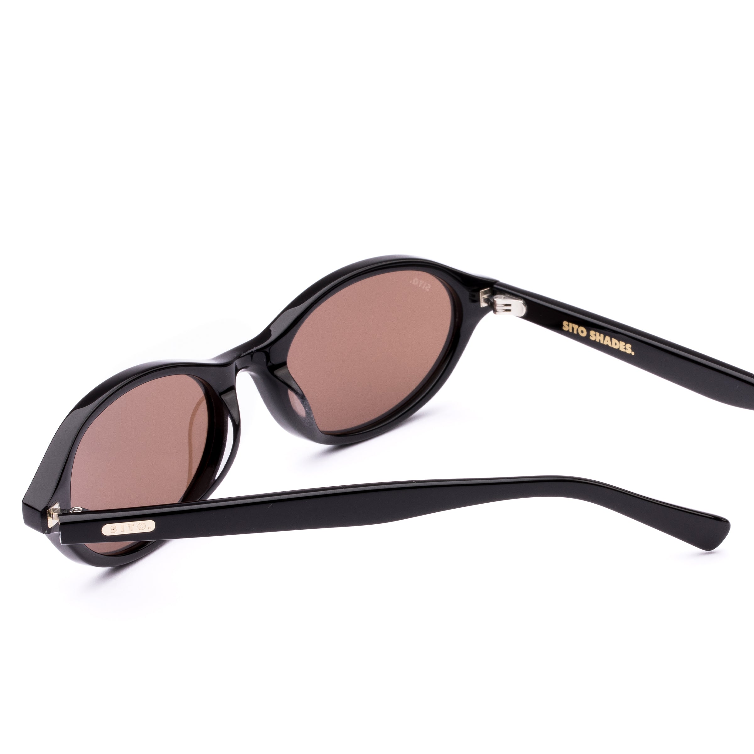Black sunglasses with brown lenses on a white background