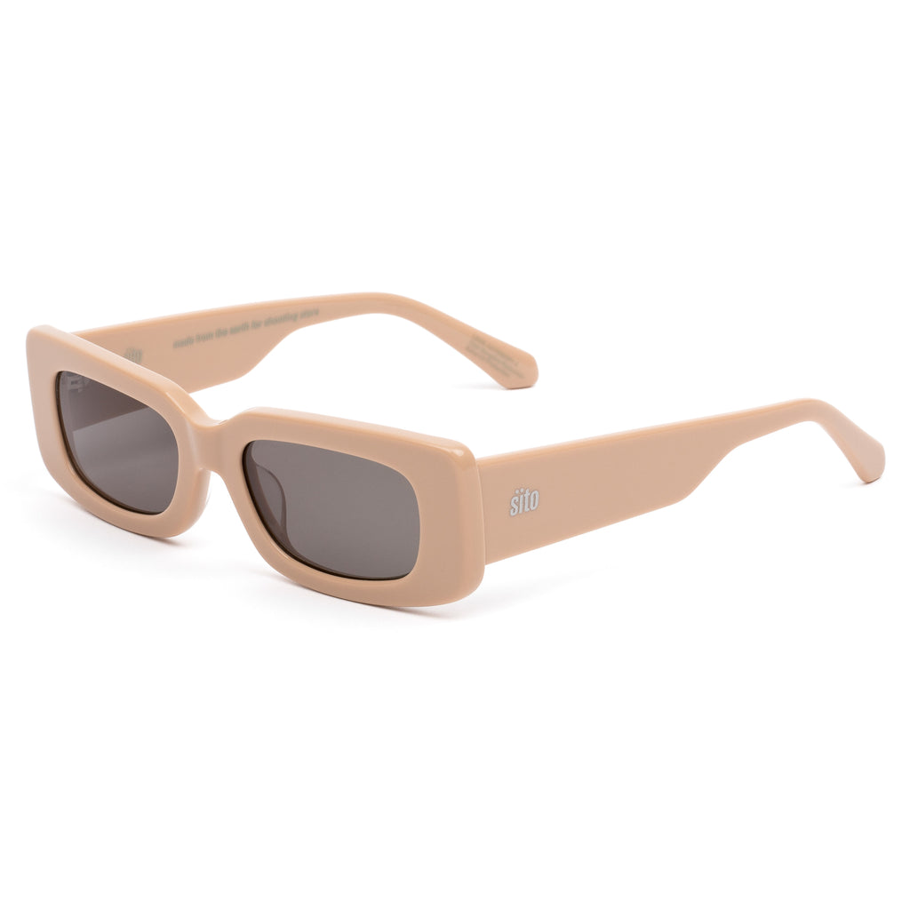 Beige sunglasses with dark lenses on a white background