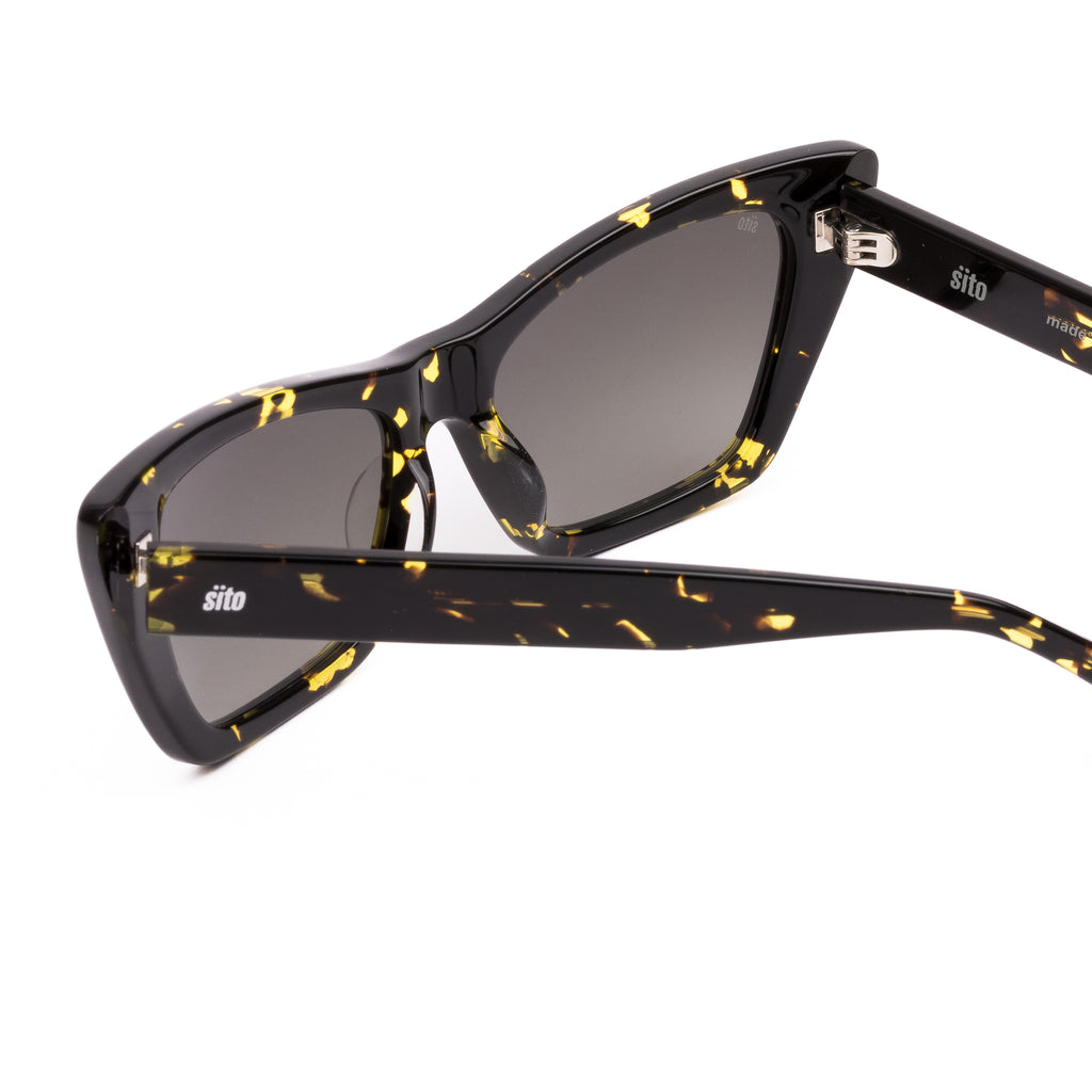 Cat-eye sunglasses with black frame and yellow accents on a white background