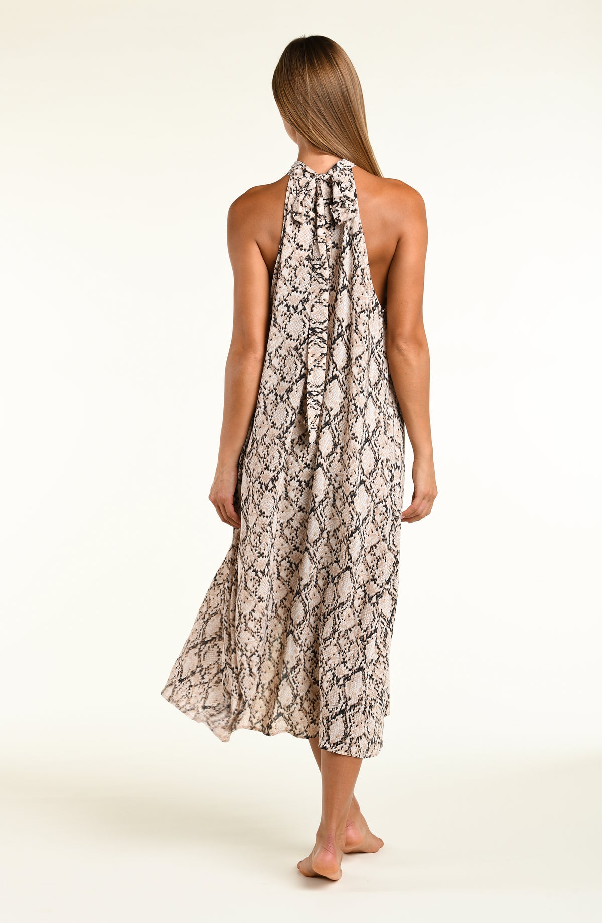 Woman wearing a snakeskin printed midi dress cover up against a white background. 