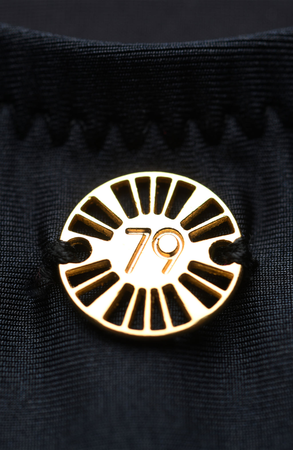 Gold circular emblem with the number 79 on a black background