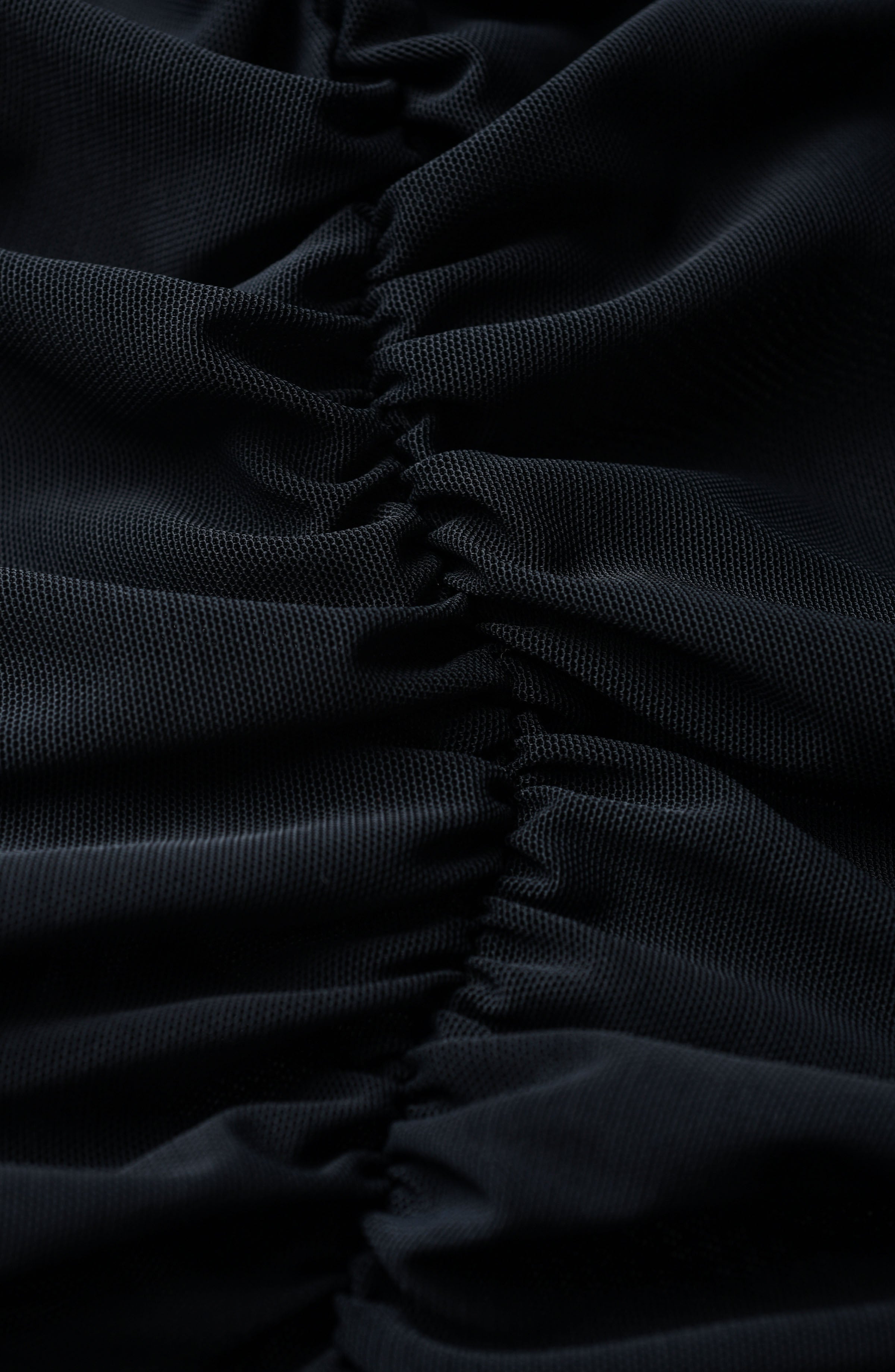Close-up of black ruched fabric with pleated texture