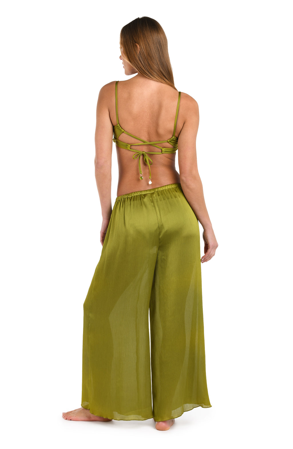 Woman wearing an olive green bikini top and pants against a white background