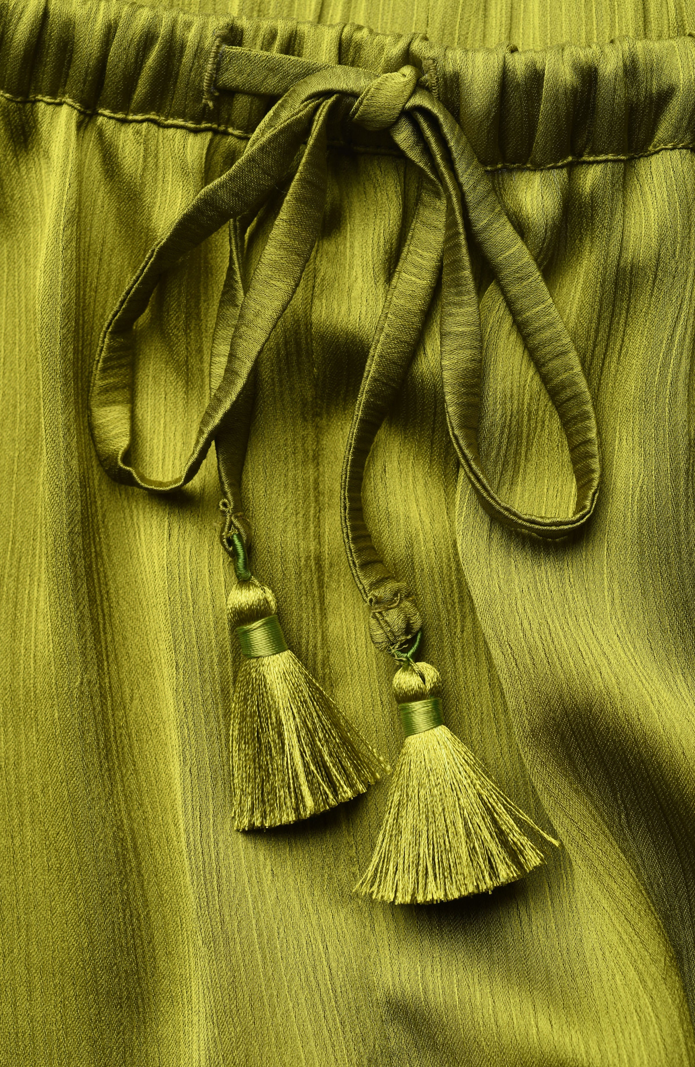 Green fabric with tassels on a matching green background