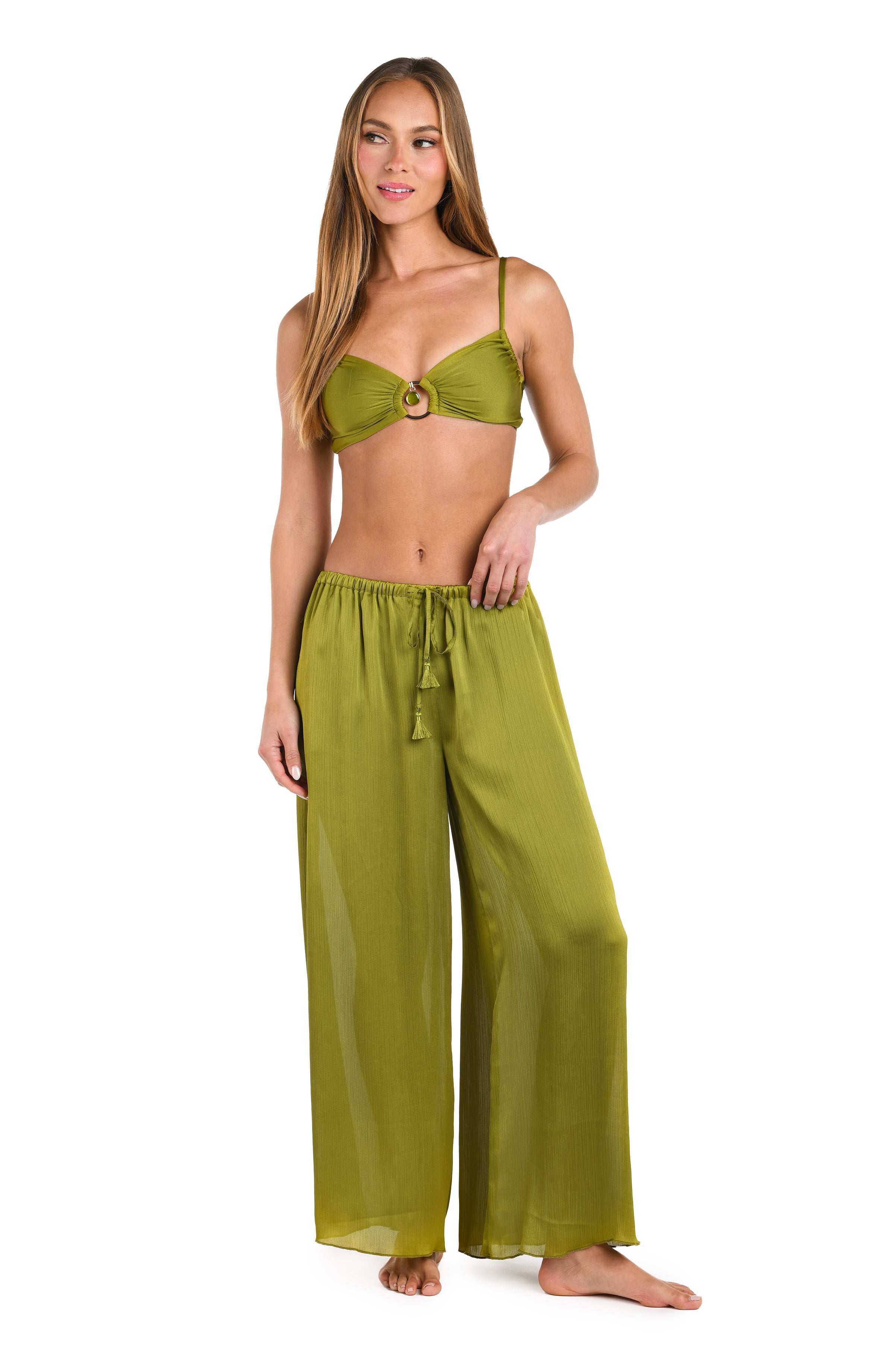 Woman wearing an olive green bikini and matching pants on a white background