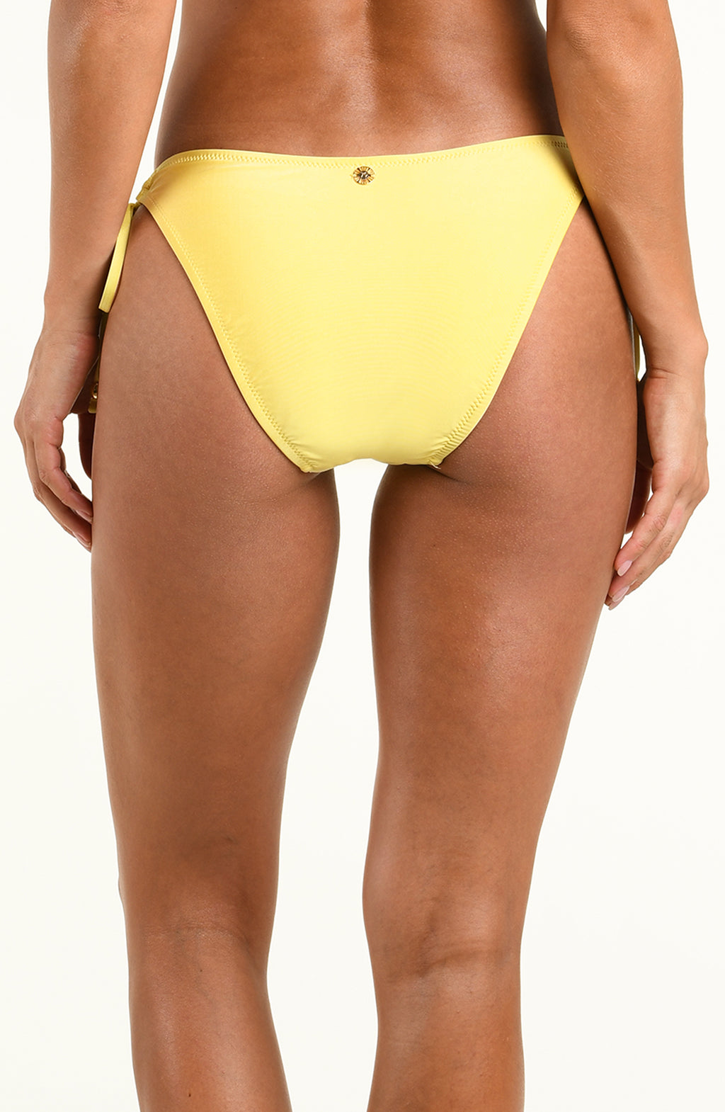 A close-up back view of a model wearing a bright yellow bikini bottom against a plain white background.
