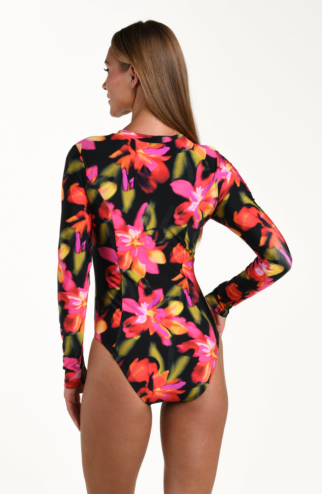 Back image of model wearing a long sleeve paddle suit one piece featuring a zipper front and moderate rear coverage, in a multicolored floral print.