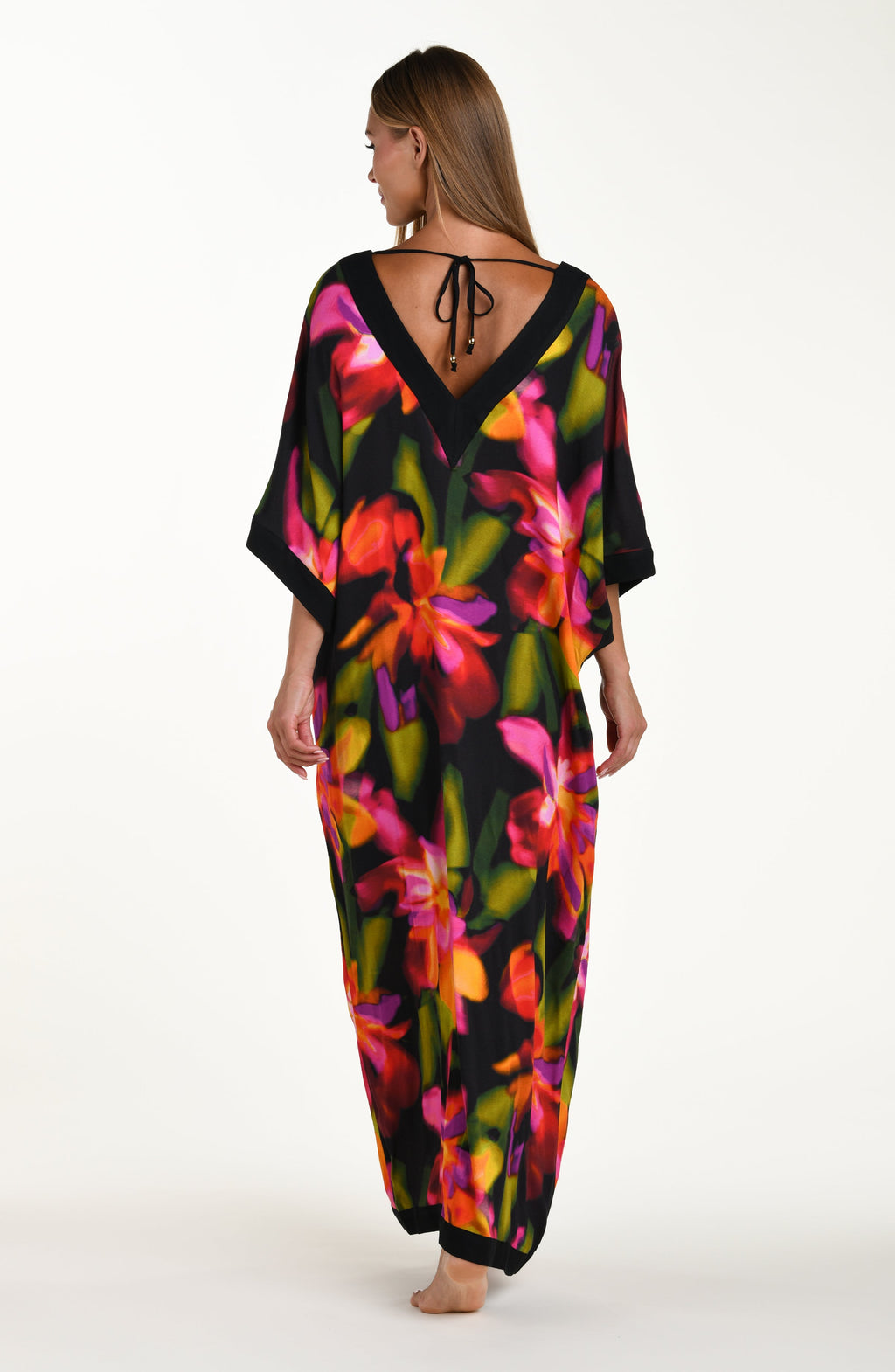 Full body back image of model wearing a long maxi dress-style cover-up featuring a deep V-neckline and vibrant oversized floral print. 