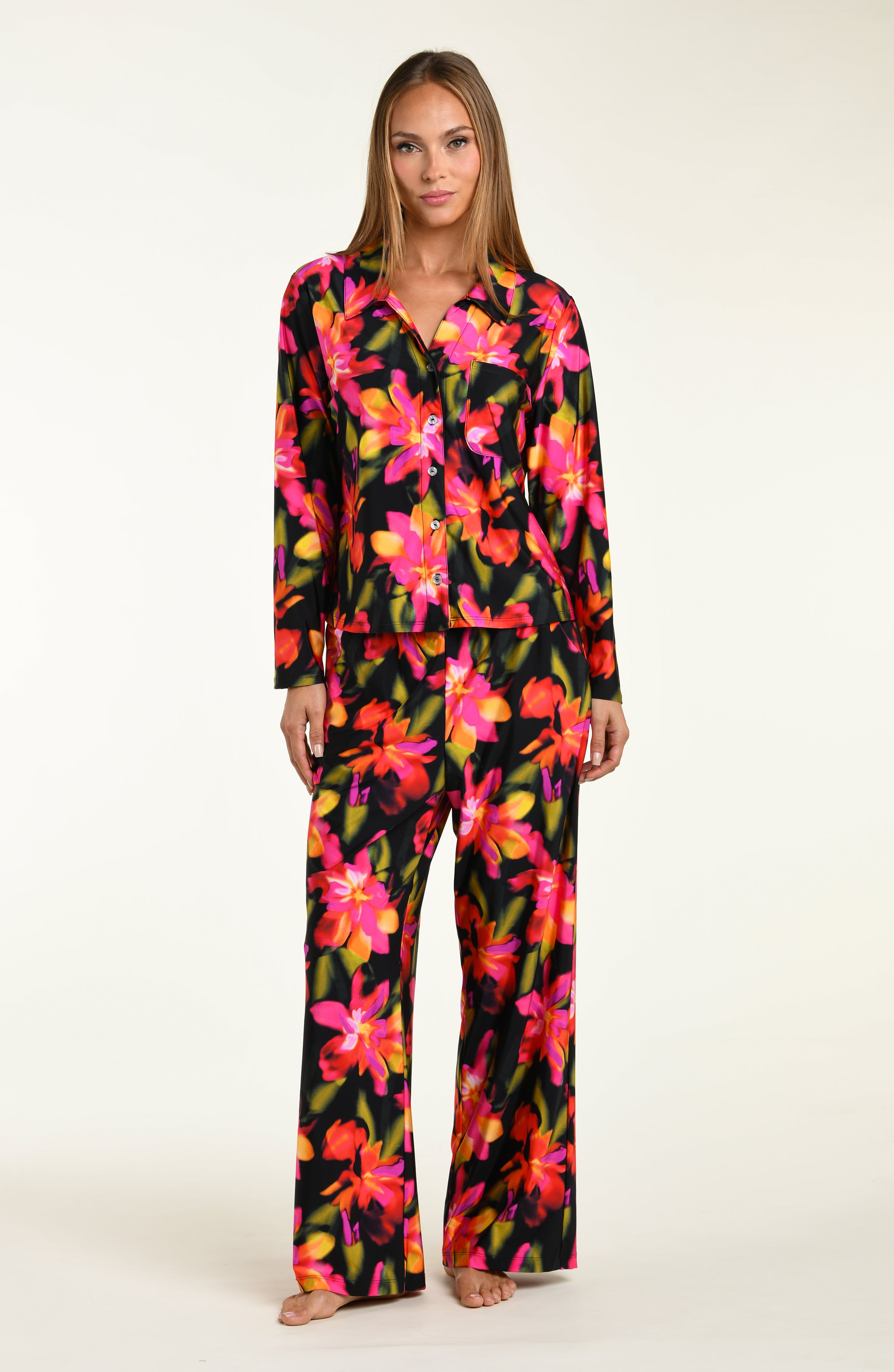 Woman wearing a colorful floral shirt and pant pajama set on a white background