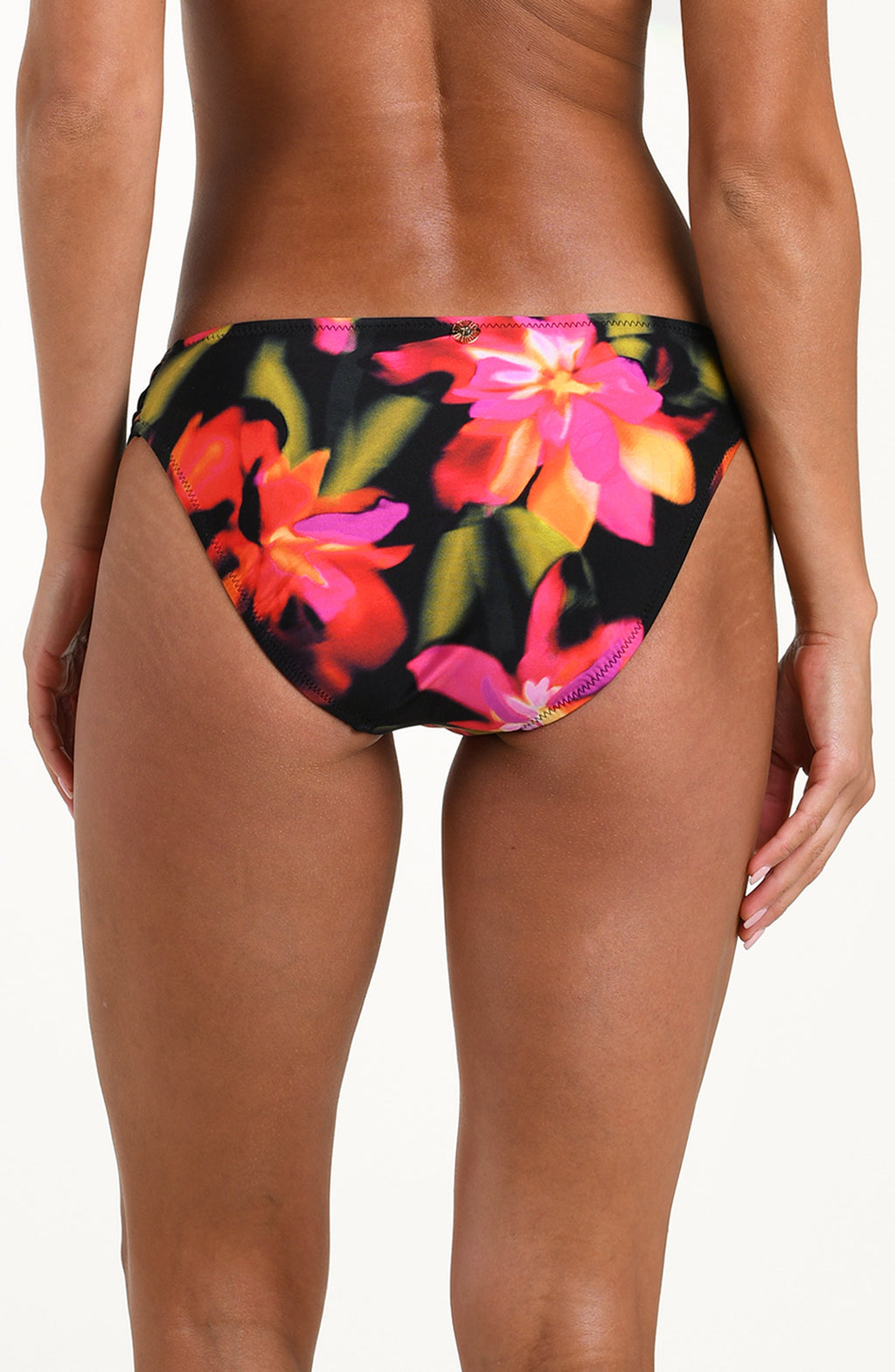 Back image of model wearing bikini bottoms with side ruching, gold charm at center, and moderate coverage in a multicolored floral print.
