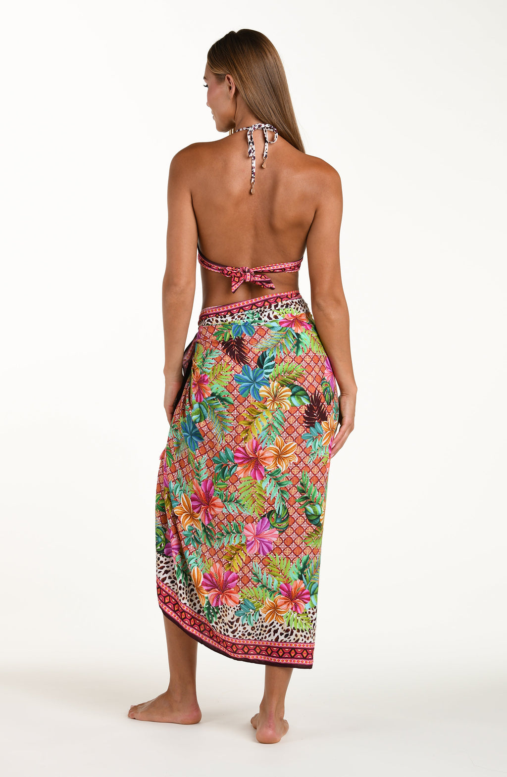 Woman wearing a colorful floral sarong on a white background