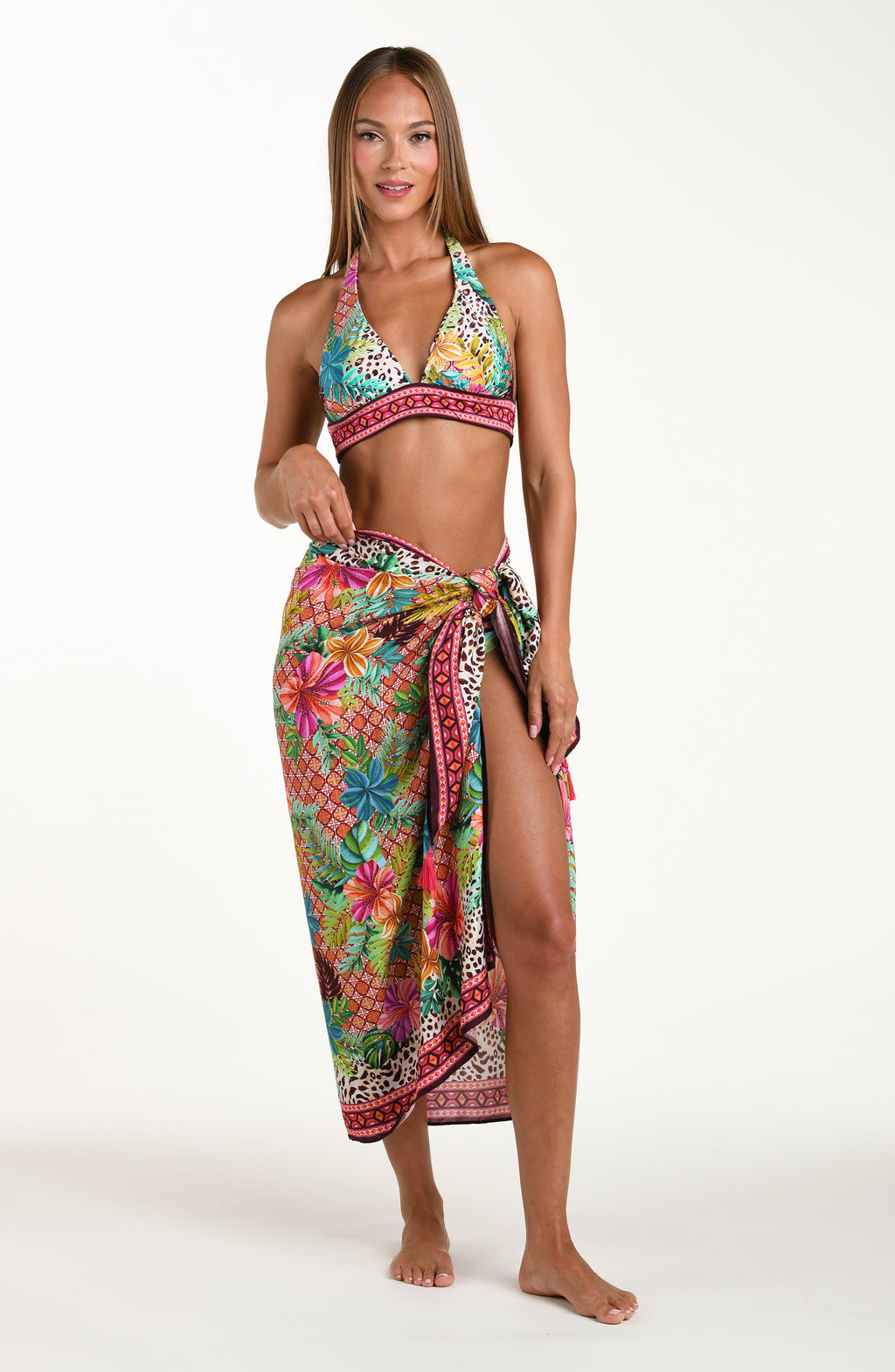 Woman wearing a colorful bikini and matching sarong on a white background