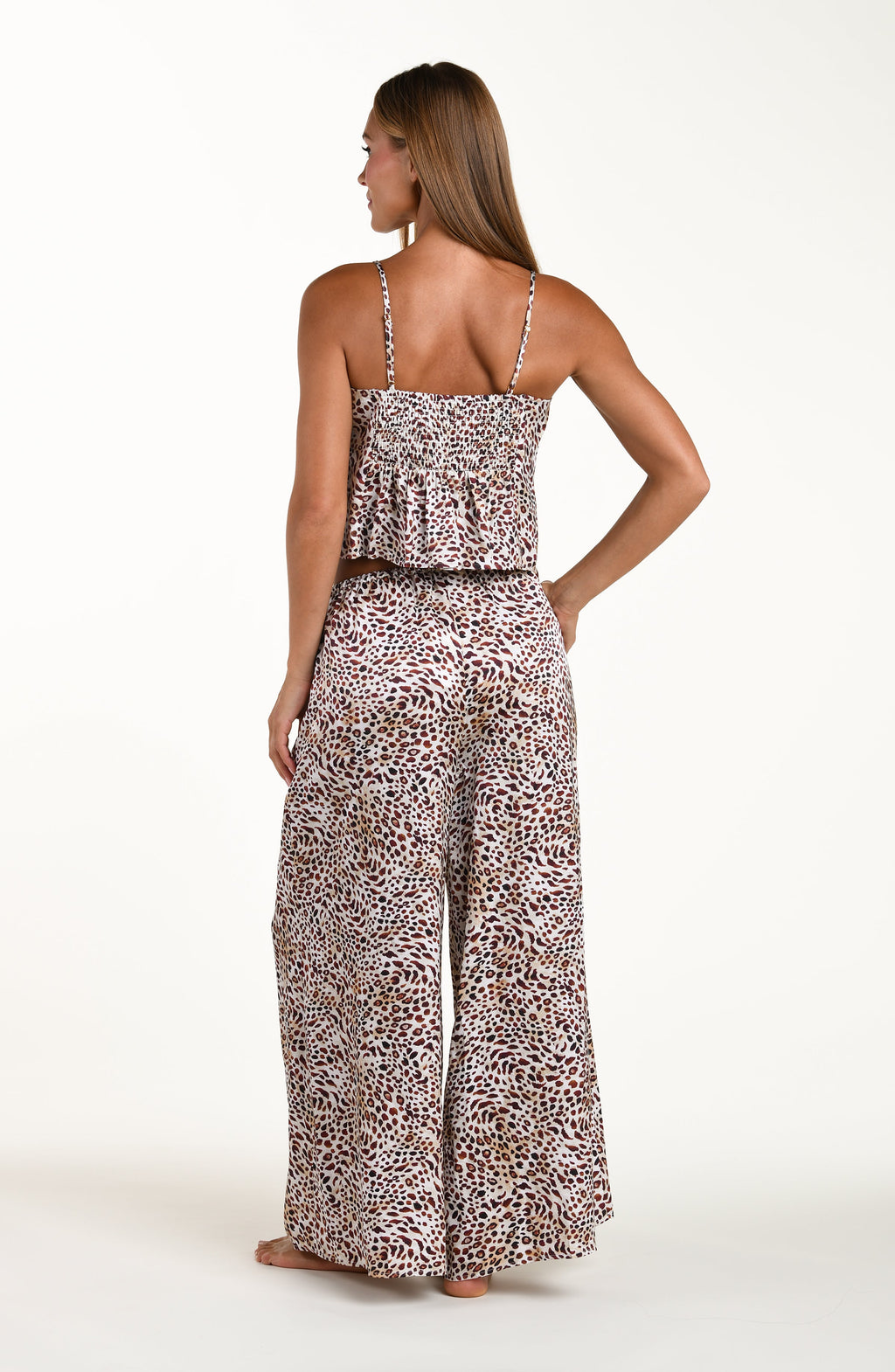 Woman wearing a leopard print jumpsuit on a white background