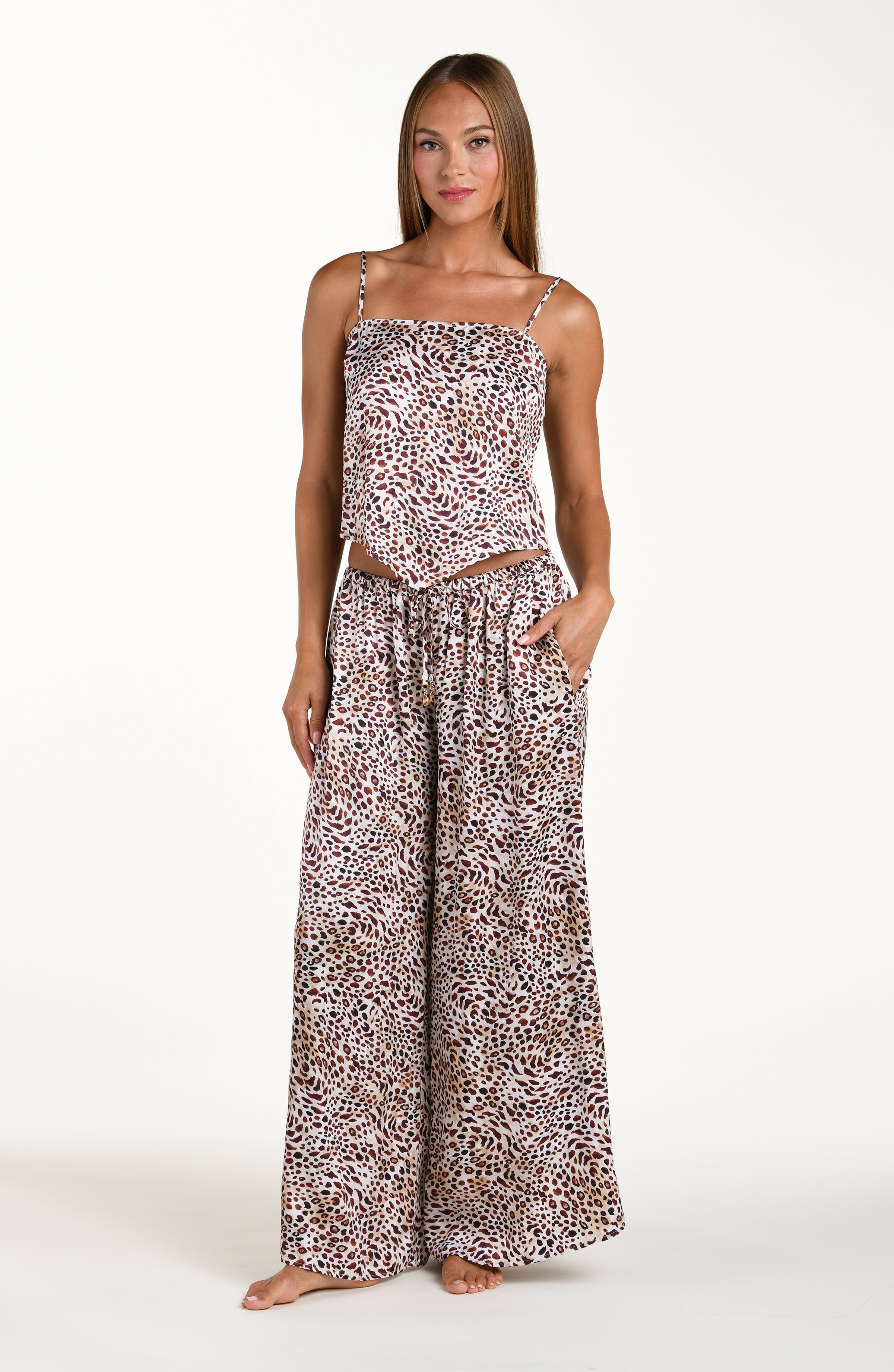 Woman wearing a leopard print strapless top and wide-leg pants on a white background