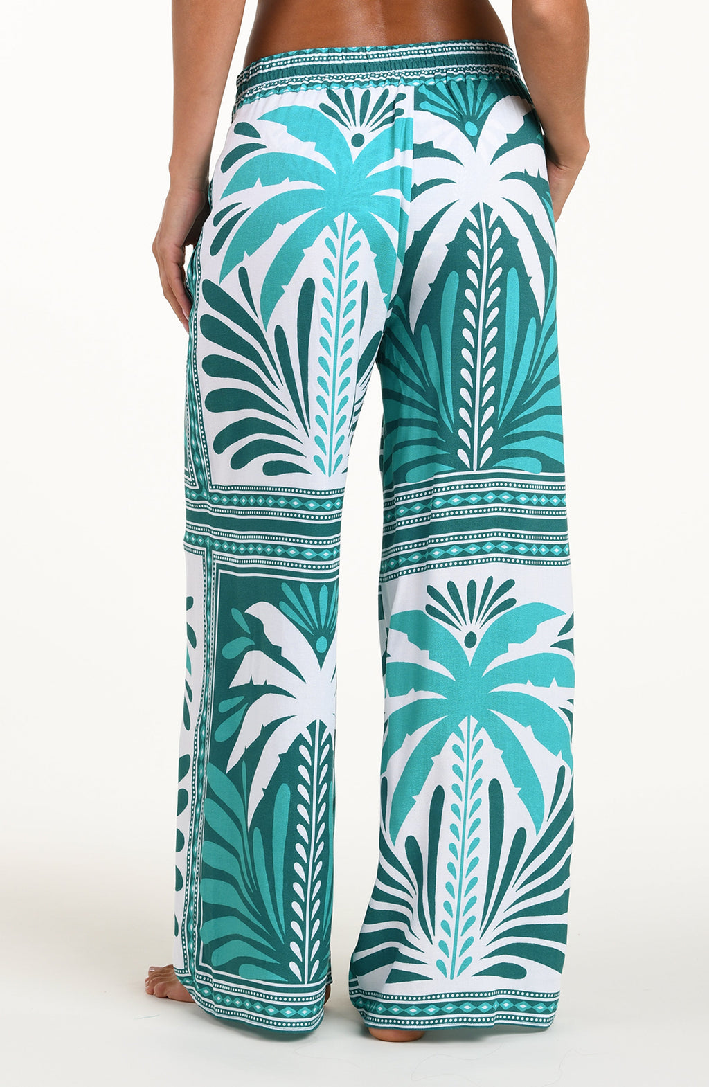 Tropical patterned pants with palm trees on a white background