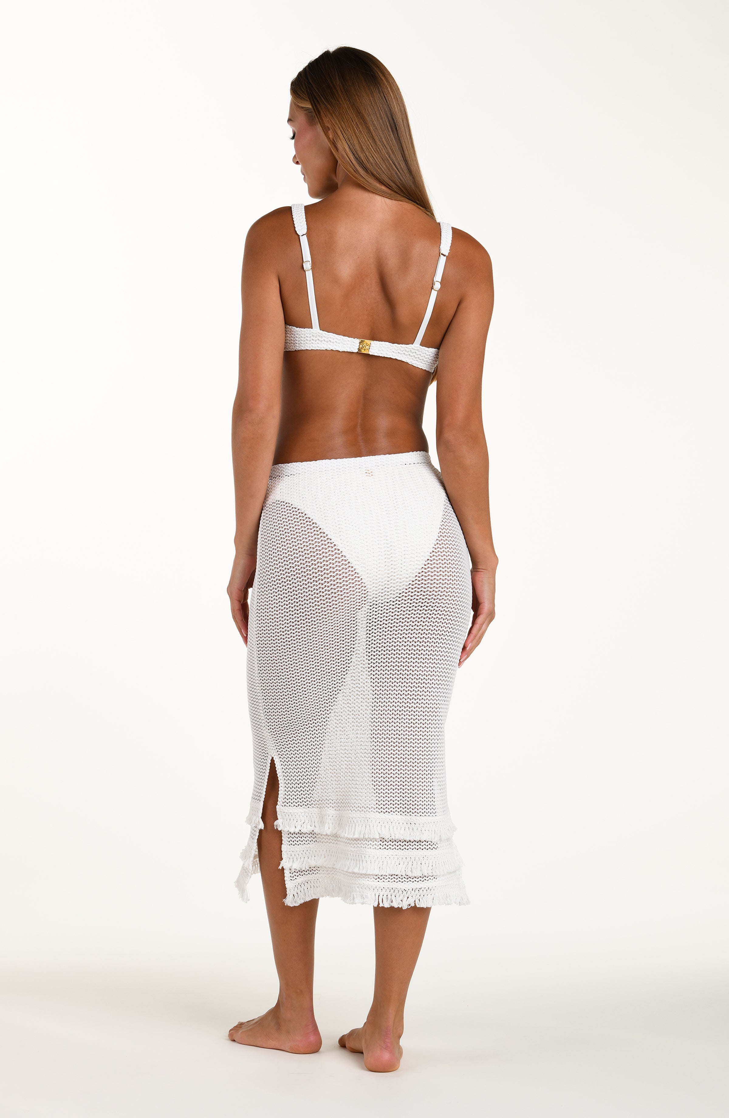 Woman wearing a white bikini and mesh skirt on a white background