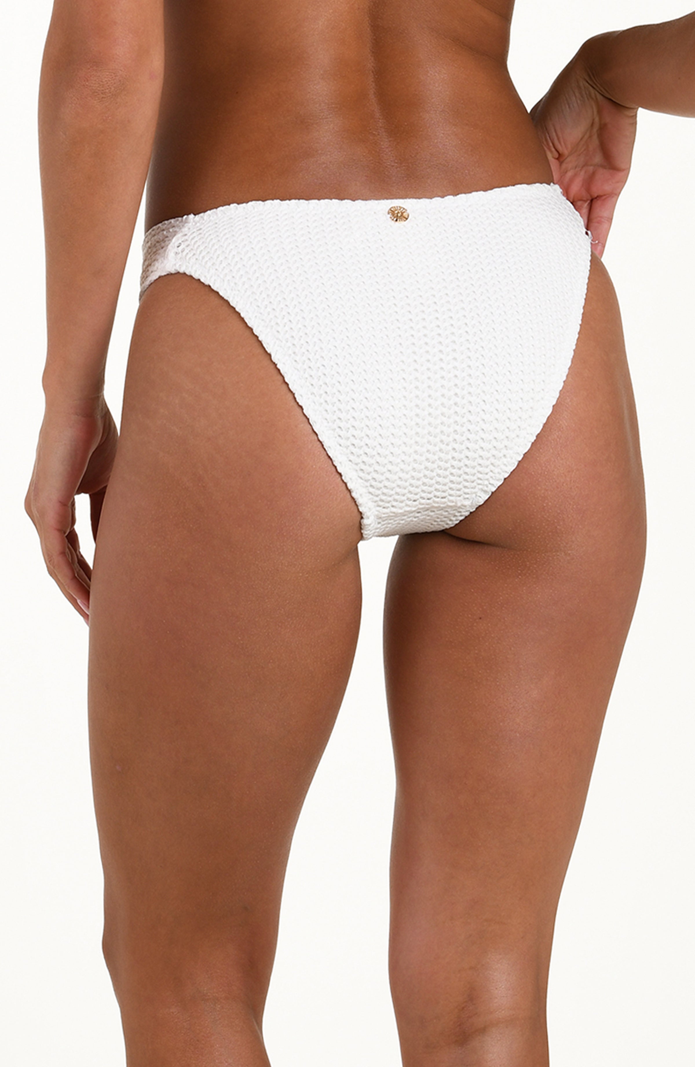 White bikini bottom worn by a person on a white background