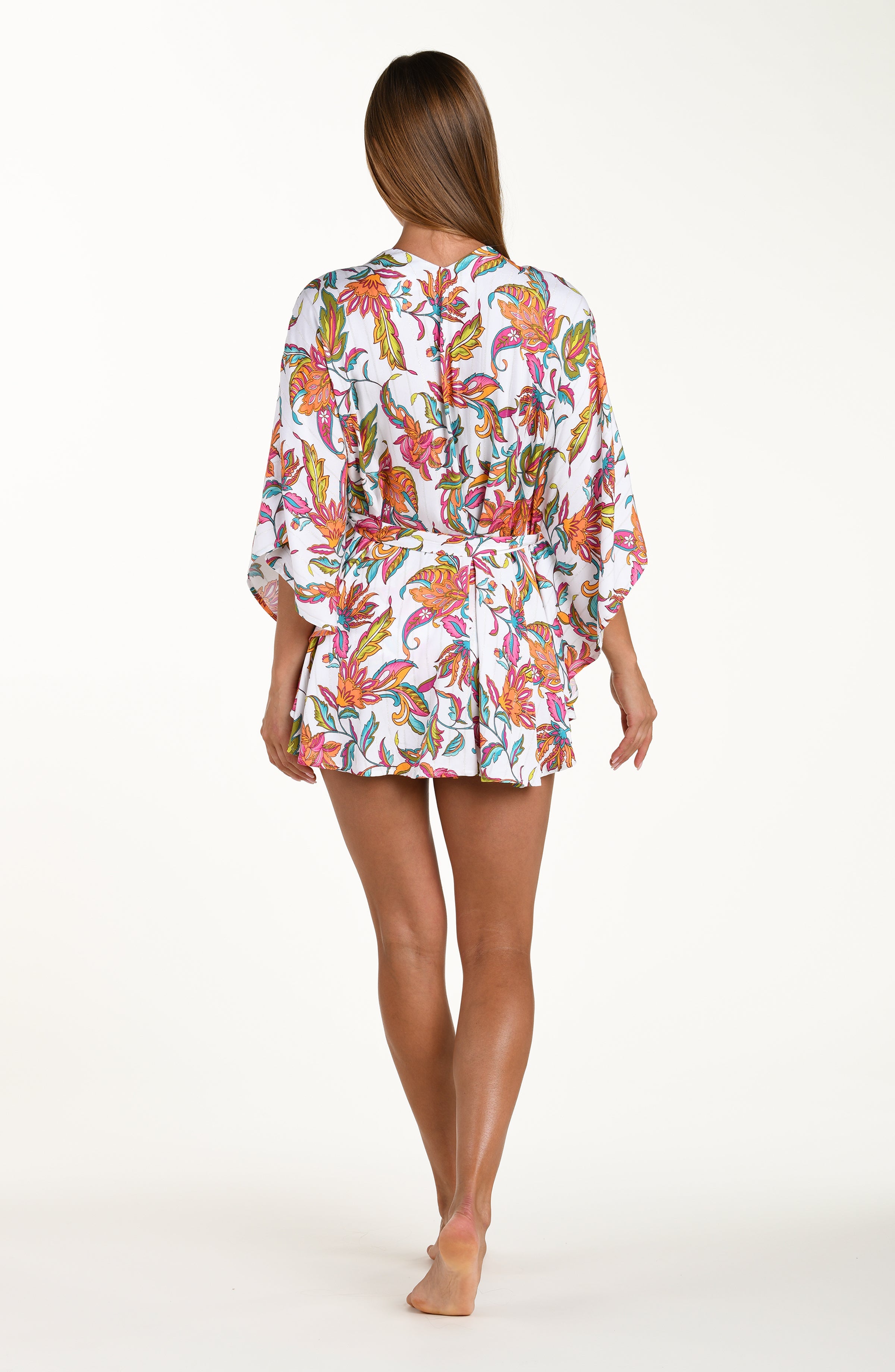 Woman wearing a colorful floral pajama set on a white background