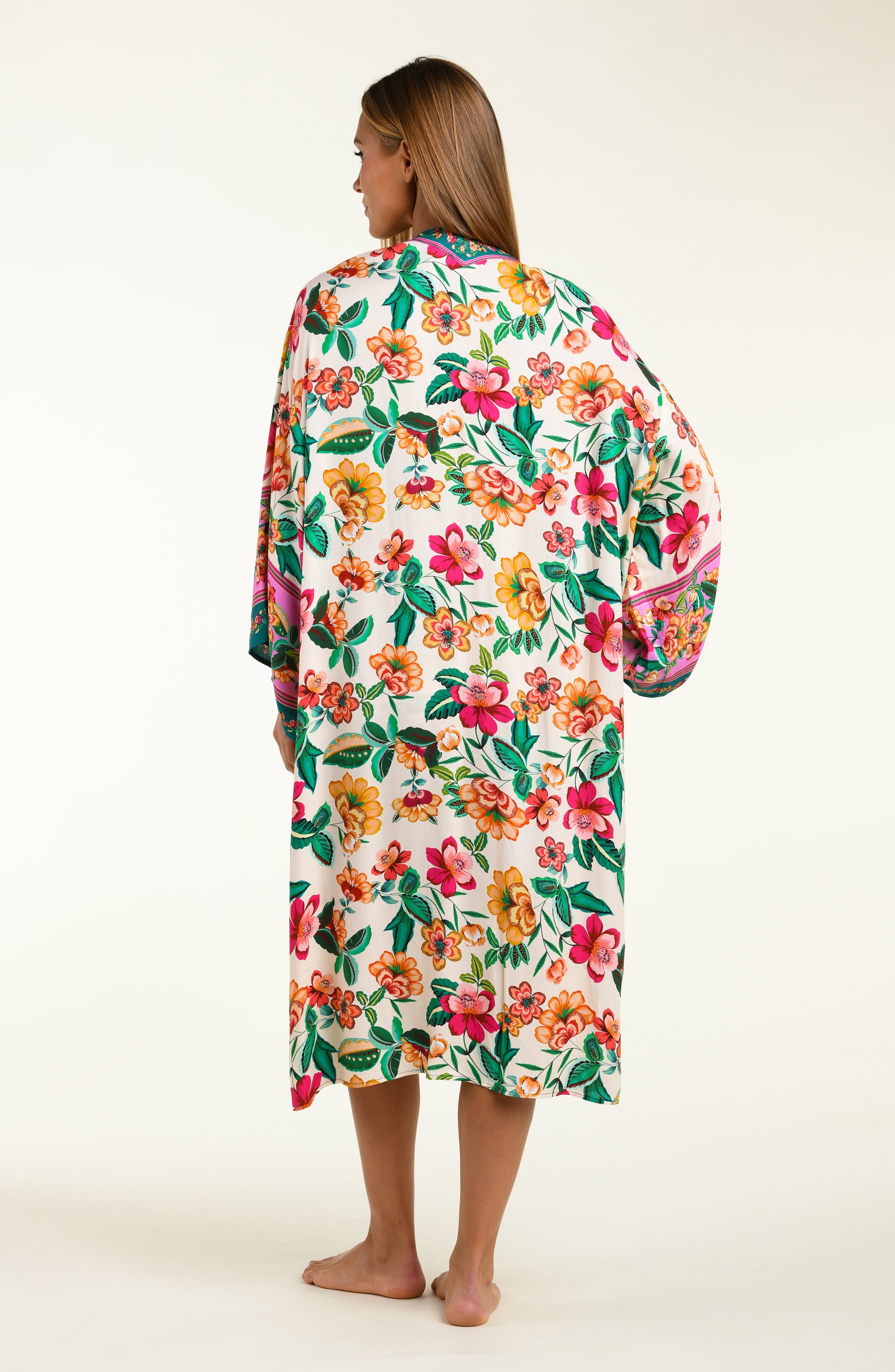 Woman wearing a colorful floral kimono cover-up on a white background