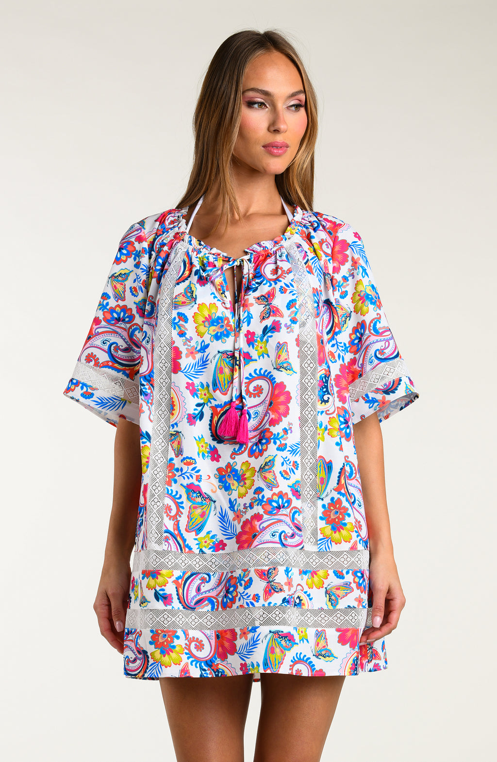 Woman wearing a multicolored tunic cover up against a white background.